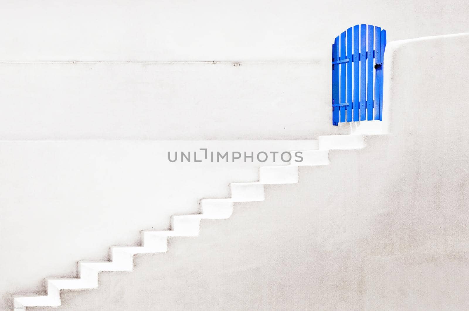 Concept of a blue door with a white wall and stairs down the door, concept of doors and stairs