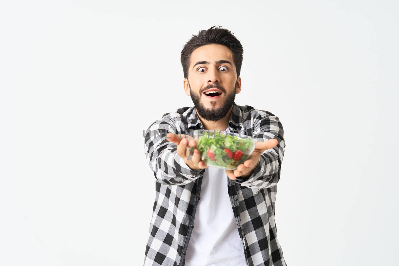 Cheerful man in plaid shirt plate with salad healthy food. High quality photo