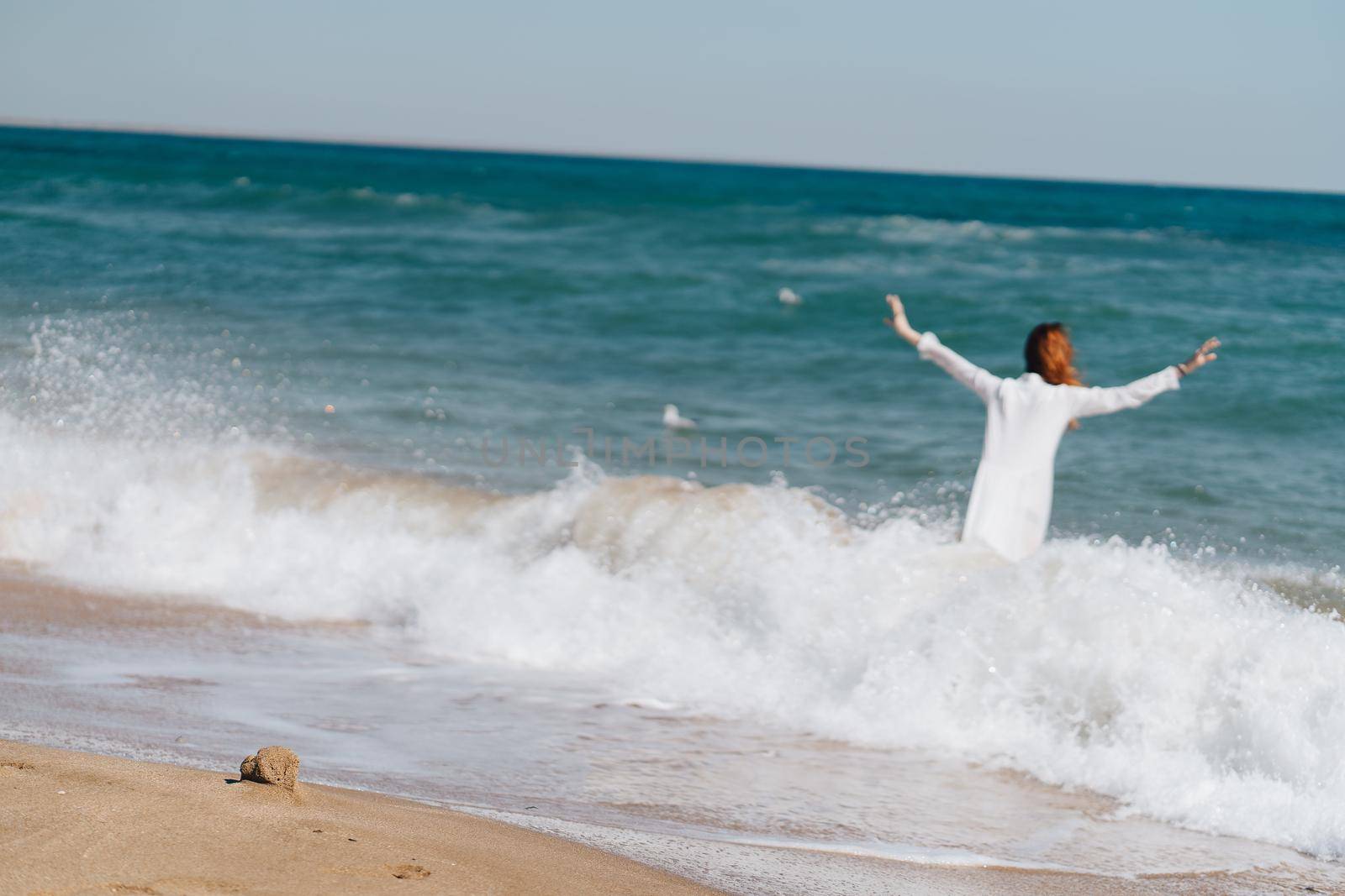 Woman in white dress near the ocean walk fresh air landscape. High quality photo