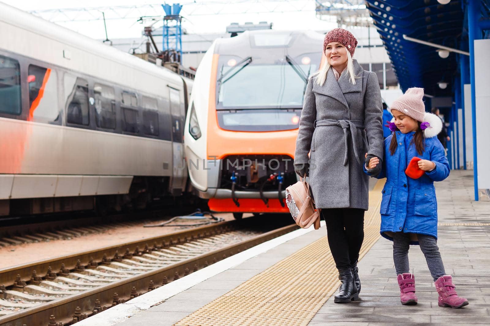 Sincere feelings of mother and daughter at a train station by Andelov13