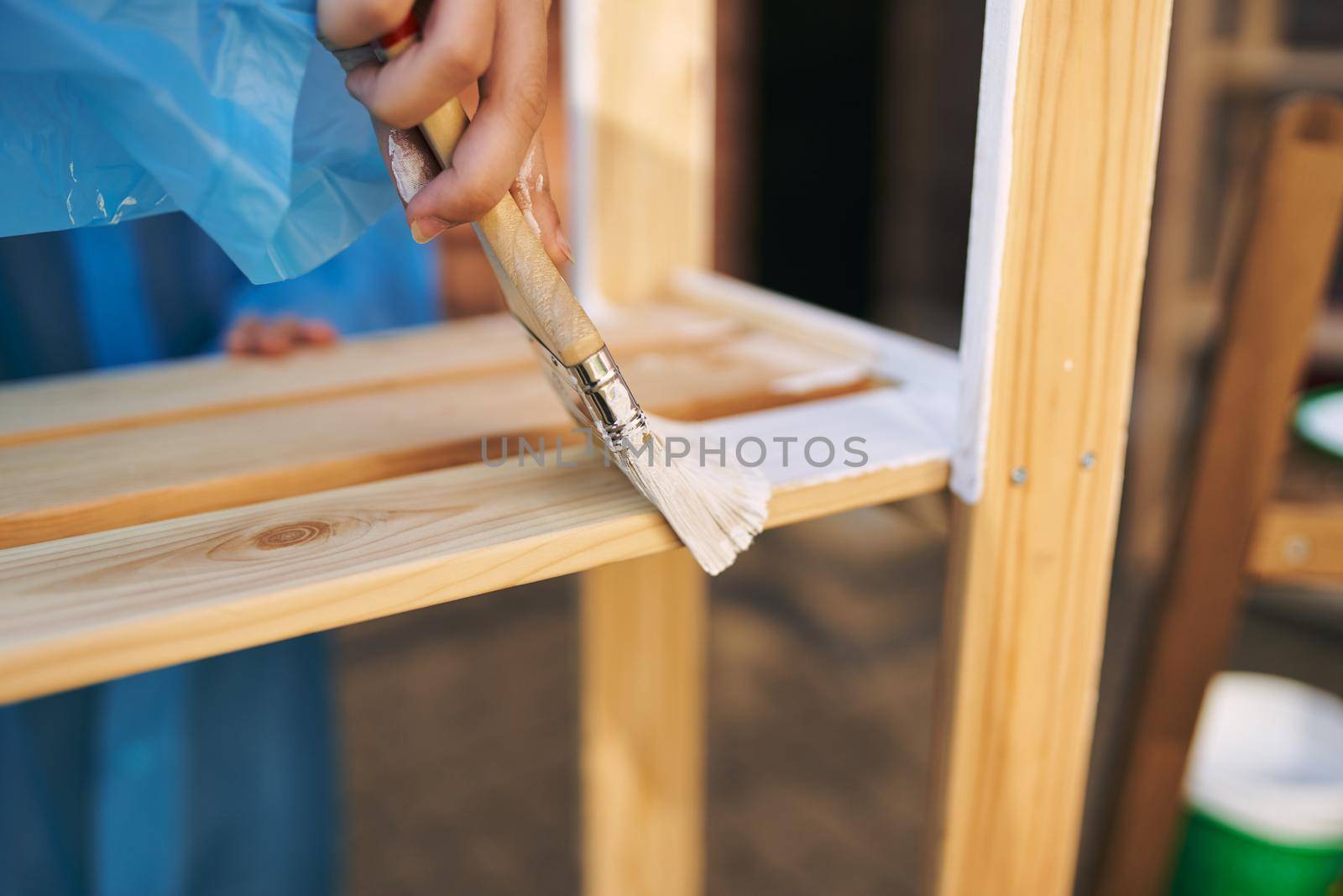 woman house painter renovating wood fittings at home. High quality photo