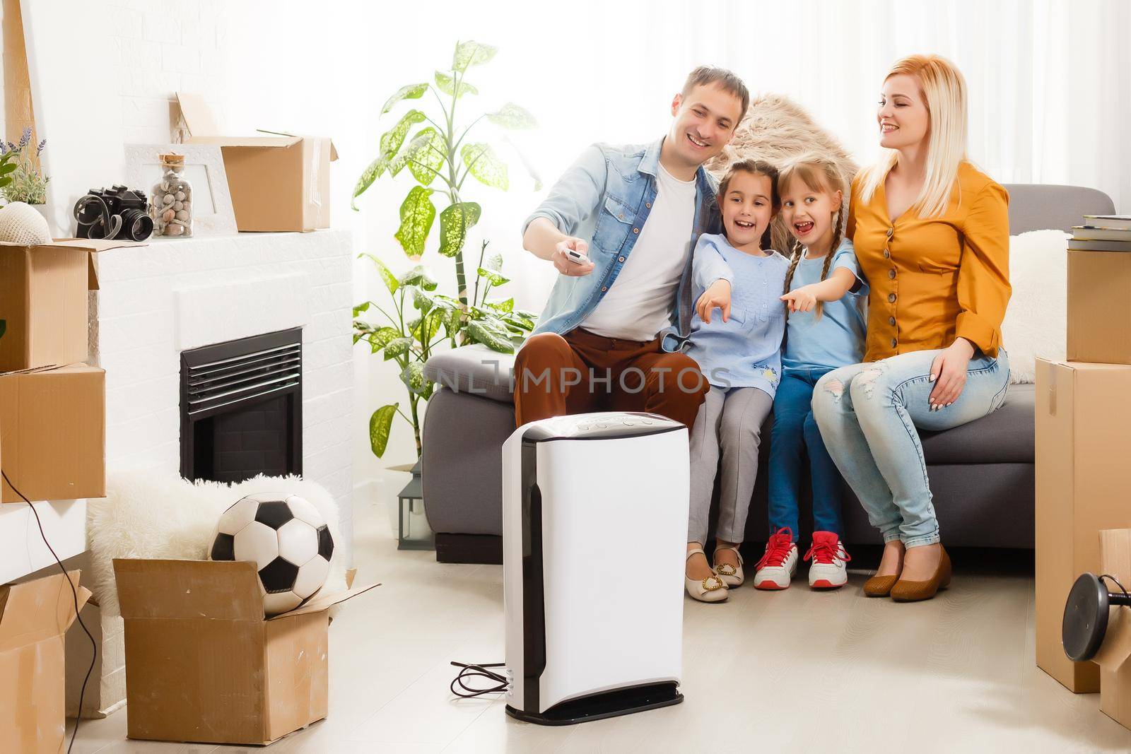 air purifier in living room with happy family moving to new apartment by Andelov13