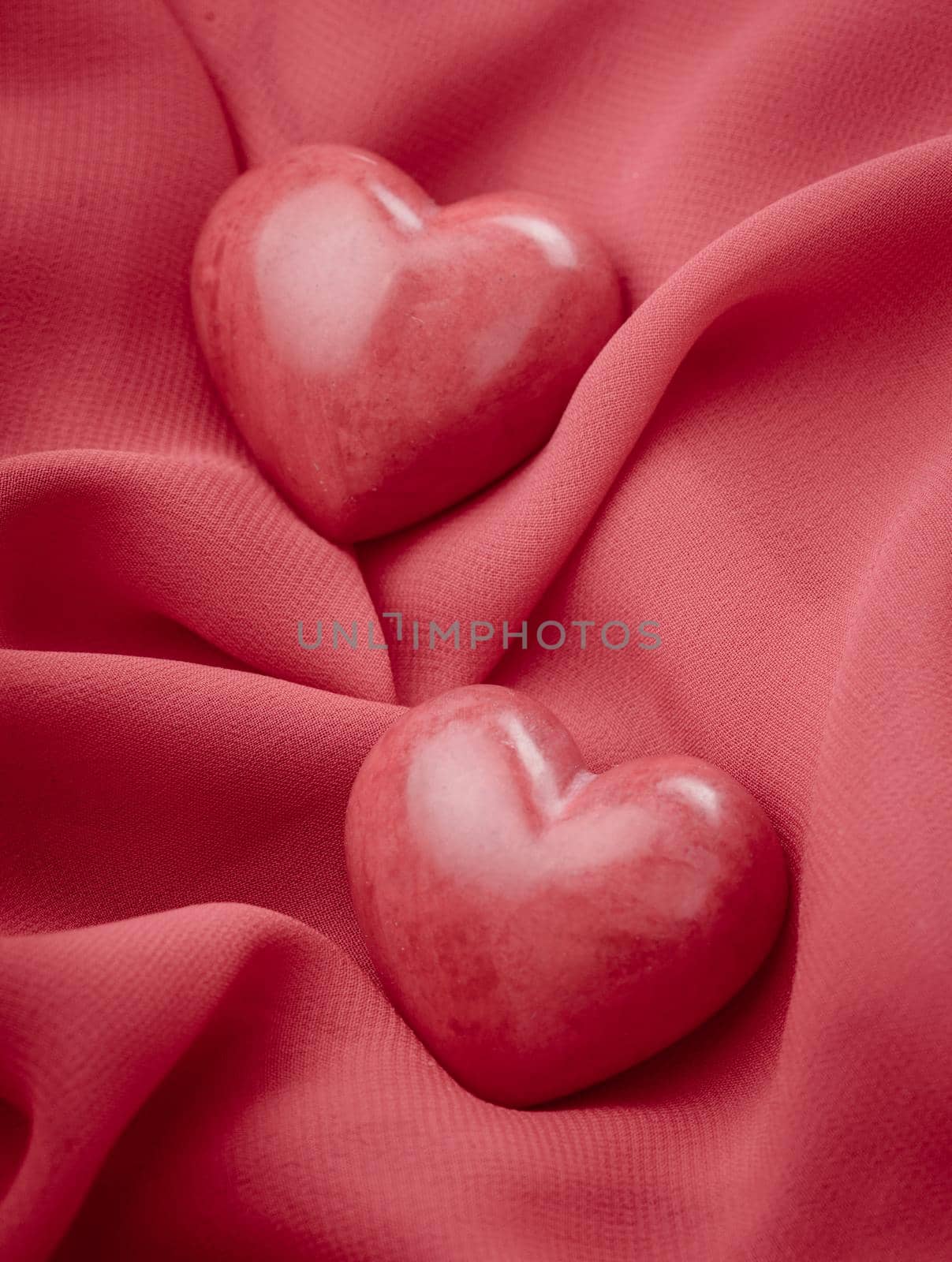 Two valentine hearts on red textile. Valentine's day concept