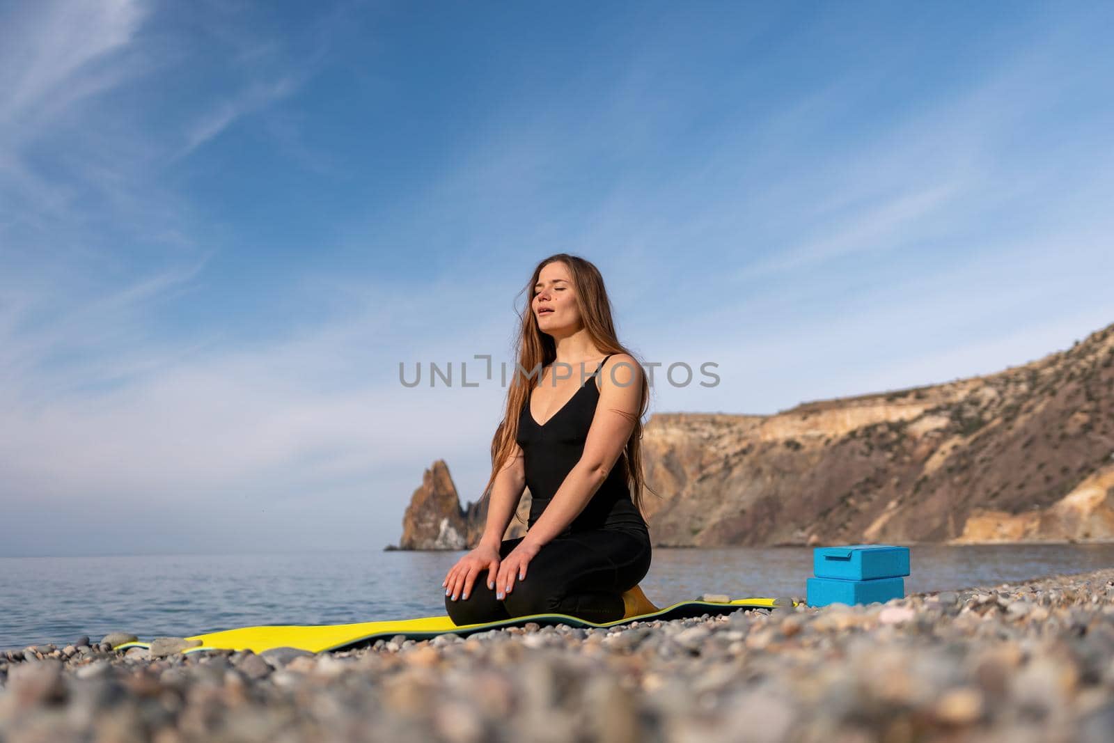 Group of young womans fitness instructor in Sportswear Leggings and Tops, stretching in the gym before pilates, on a yoga mat near the large window on a sunny day, female fitness yoga routine concept.