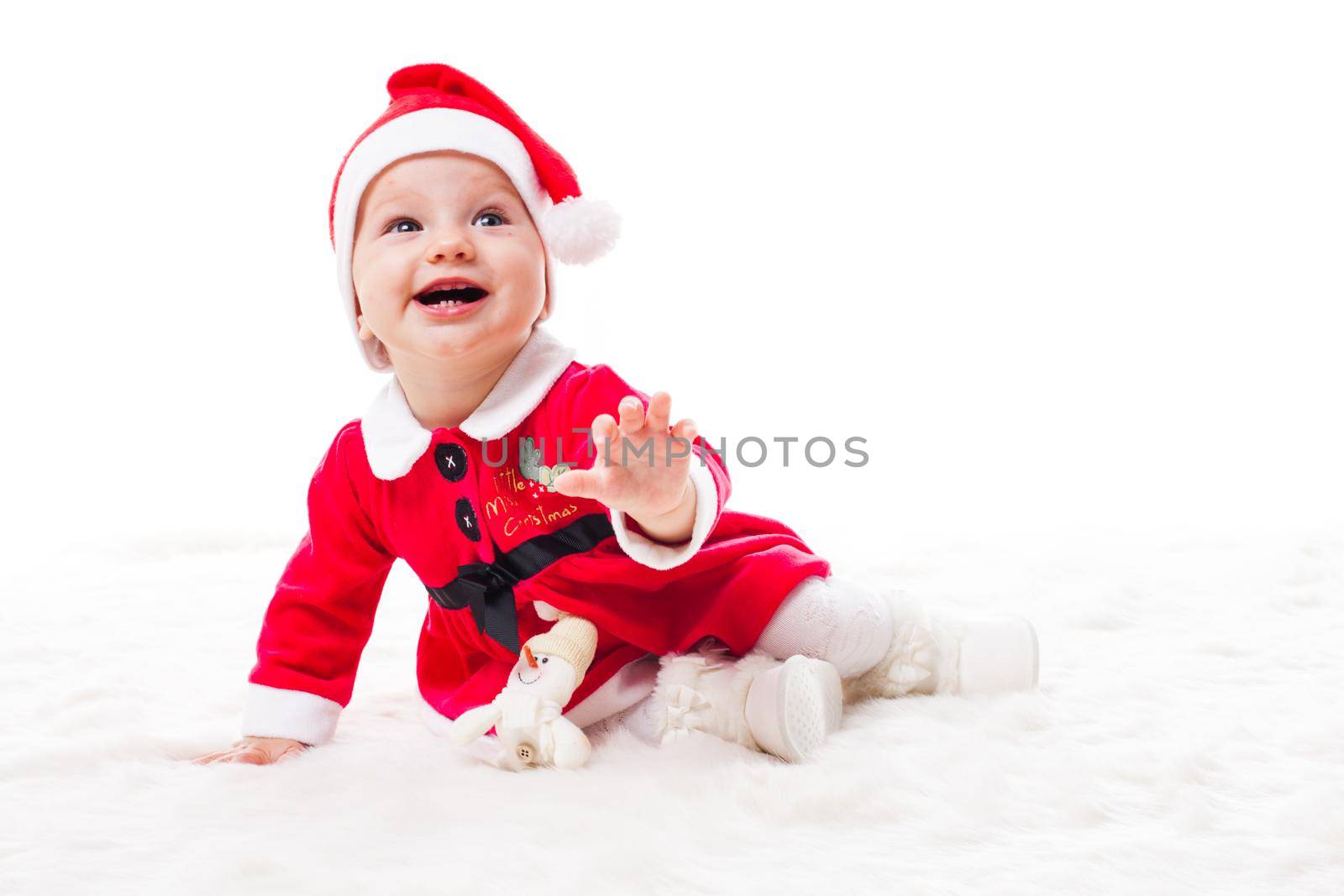 Santa baby girl with christmas toy decorations on a white fur