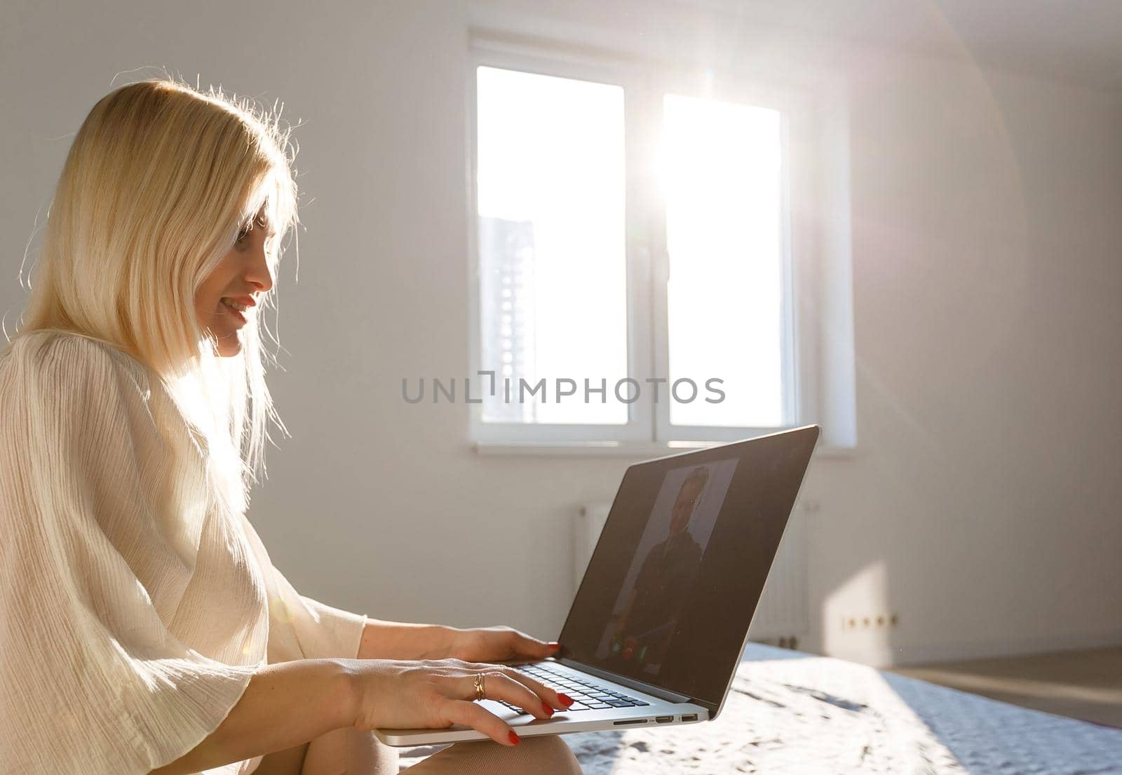 Middle-aged woman working from home on laptop by Andelov13