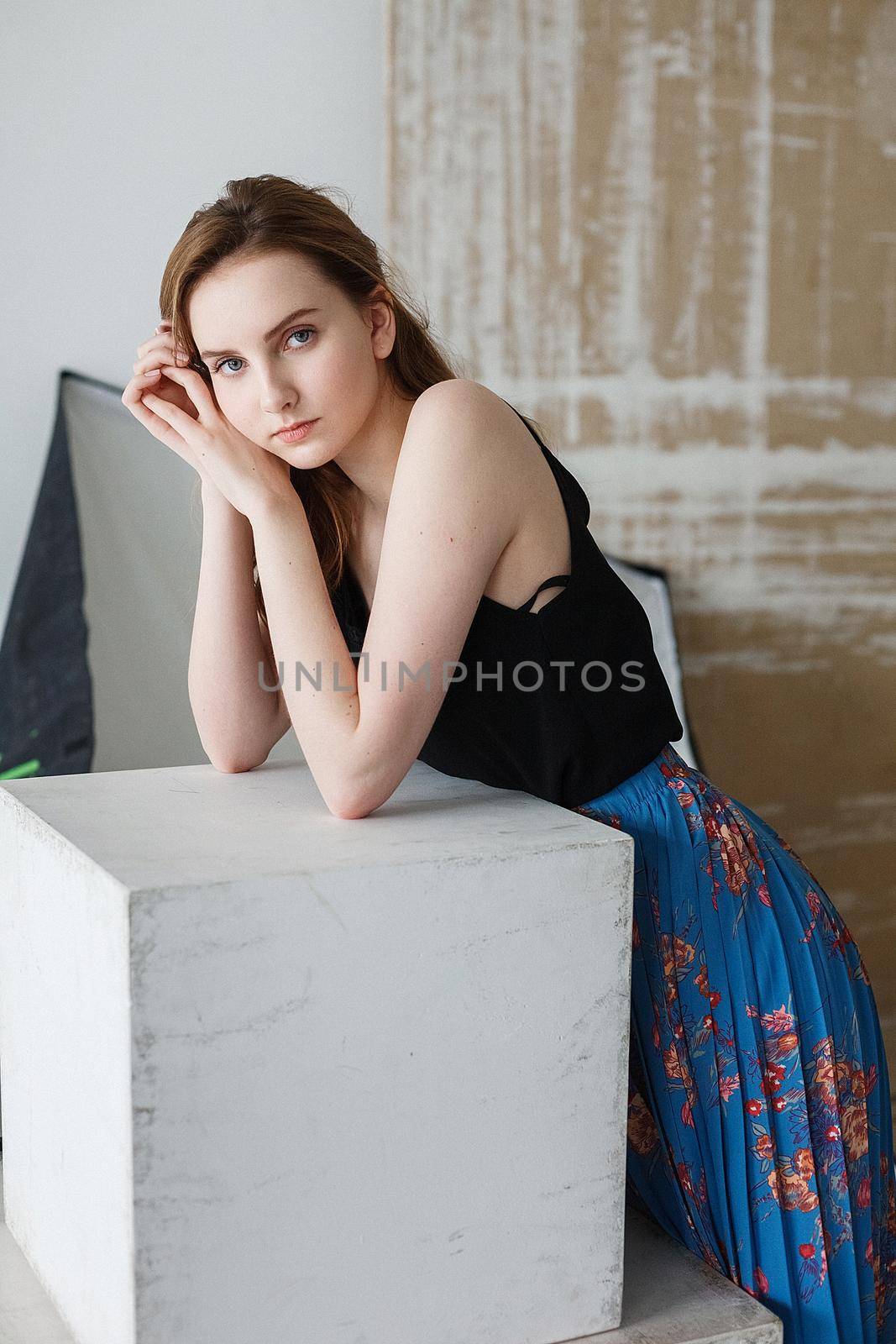 cute young pretty woman with long hair posing on abstract background at studio by artemzatsepilin