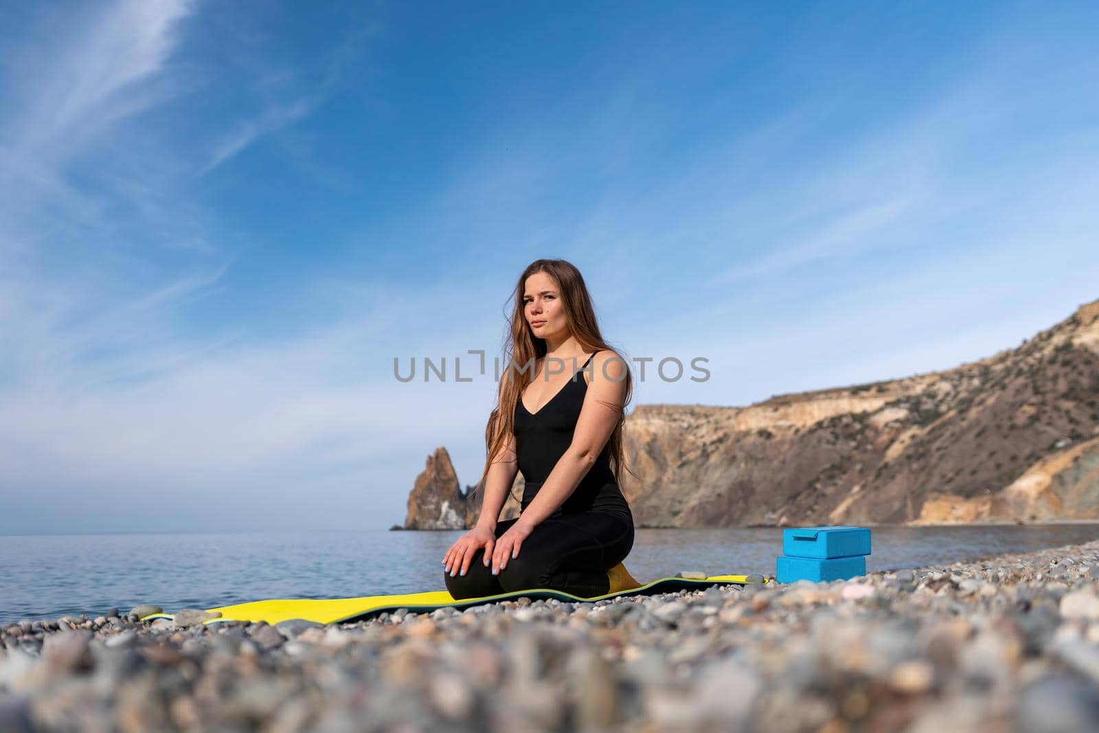 Group of young womans fitness instructor in Sportswear Leggings and Tops, stretching in the gym before pilates, on a yoga mat near the large window on a sunny day, female fitness yoga routine concept.