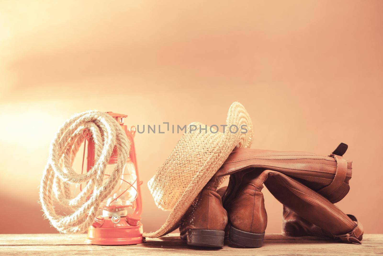 Old vintage cowboy tools - leather footwear, stetson, rope and kerosene lamp