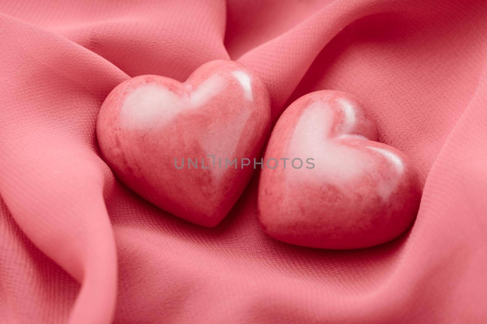Two valentine hearts on red textile. Valentine's day concept