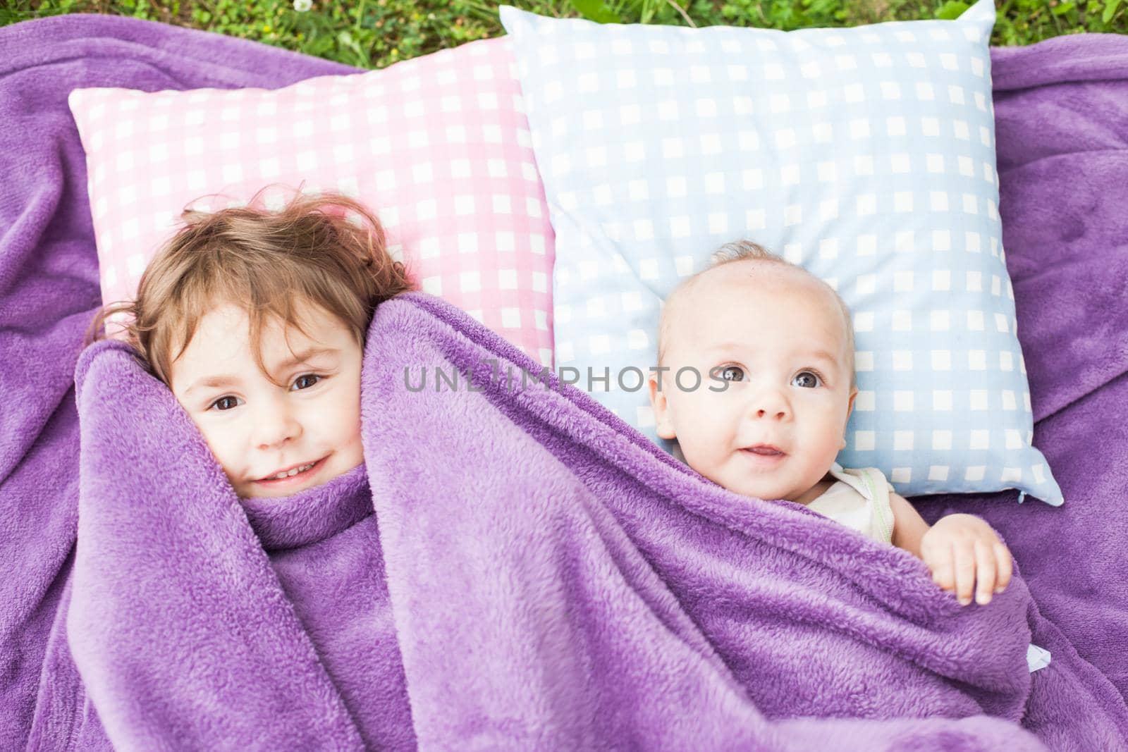 sister and brother play on the pillows