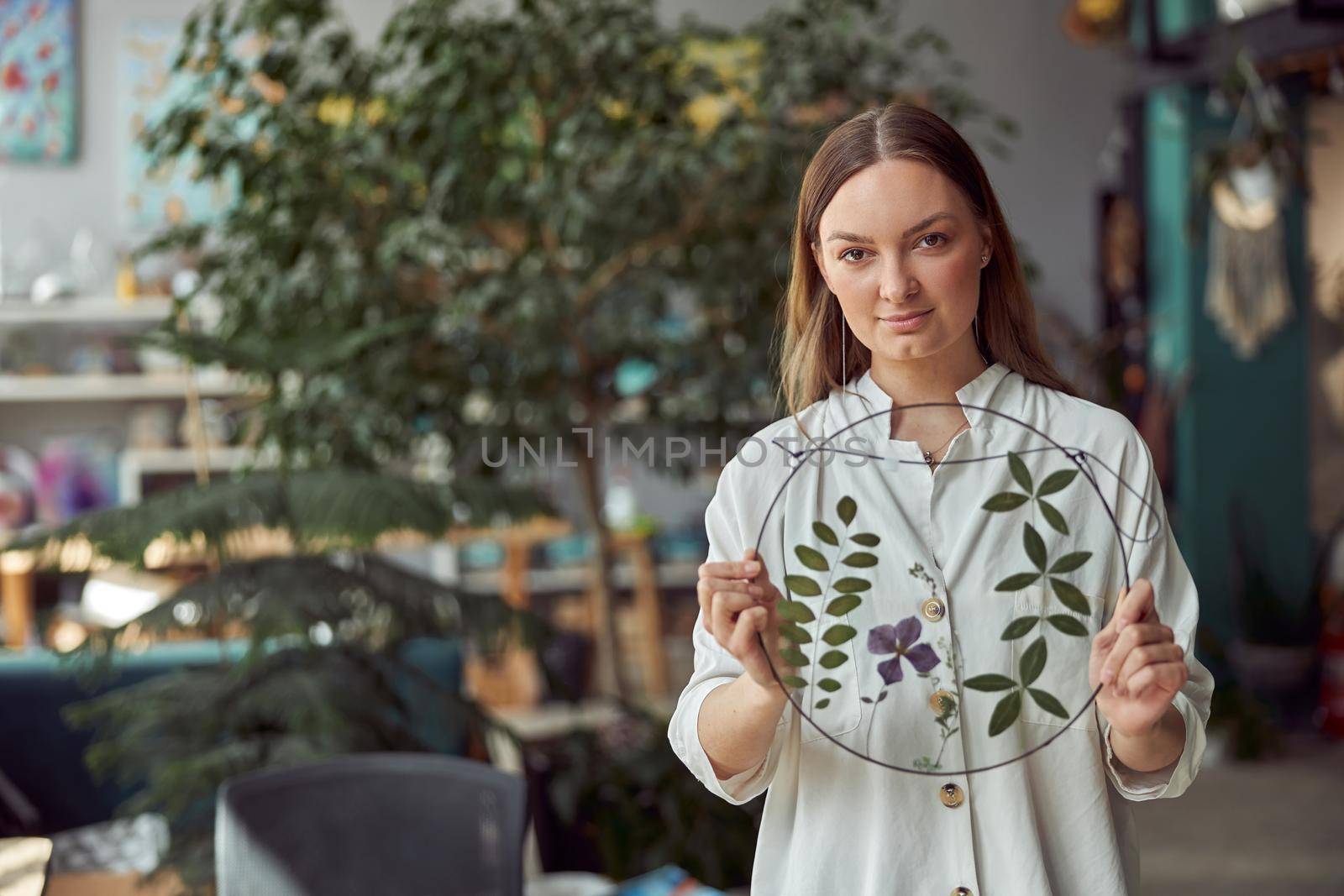 Young female caucasian woman florist is holding her work