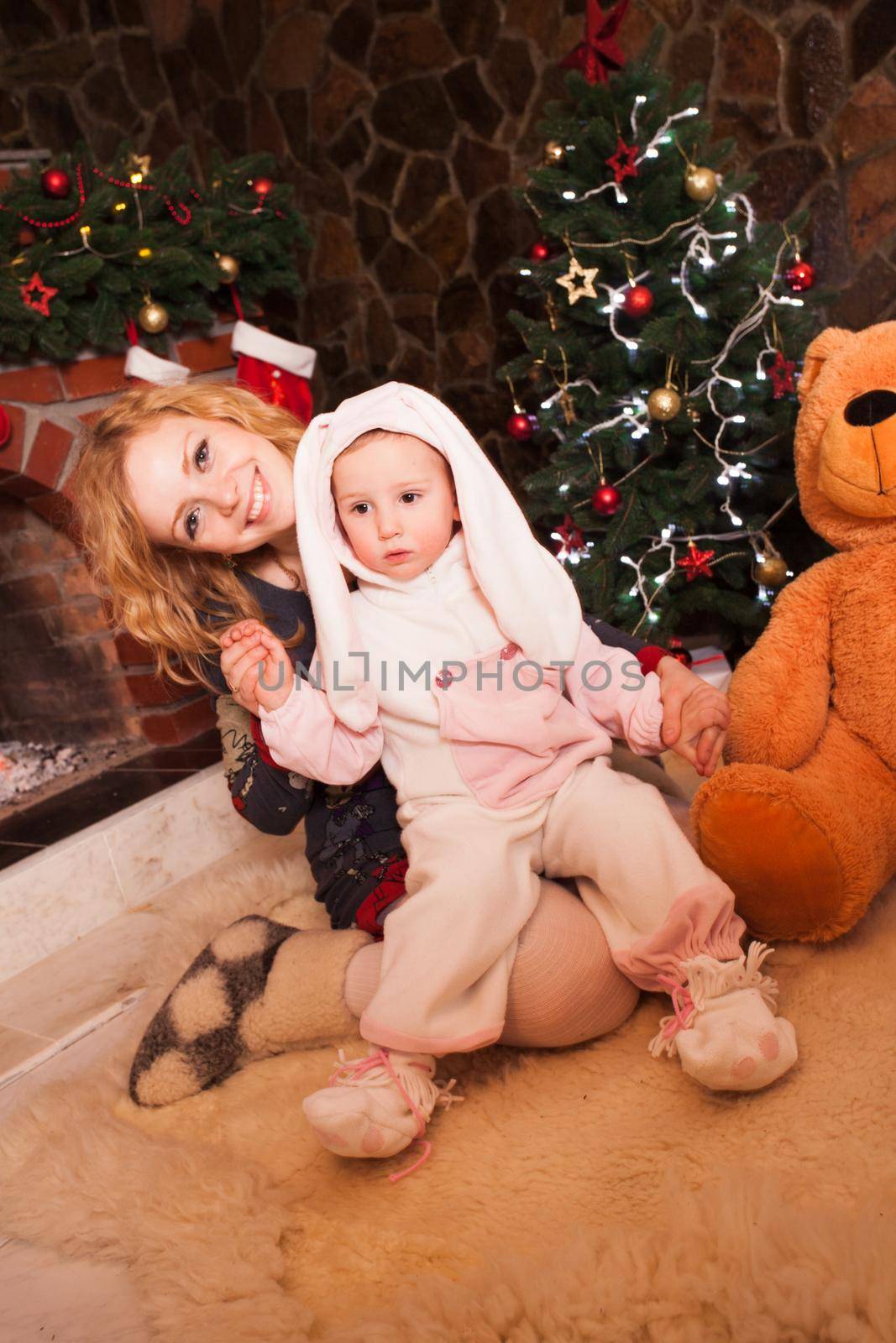 Mother with son in a rabbit costume. New year holiday decorations