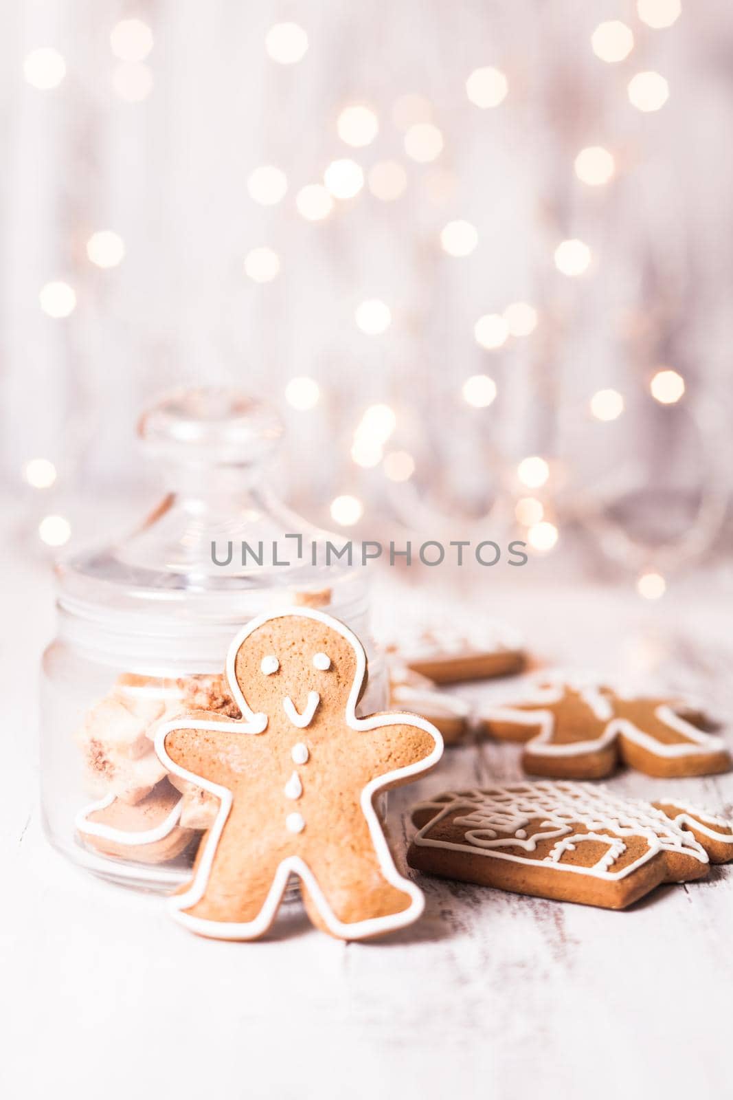 Gingerbread cookies on a table and Christmas lights on background