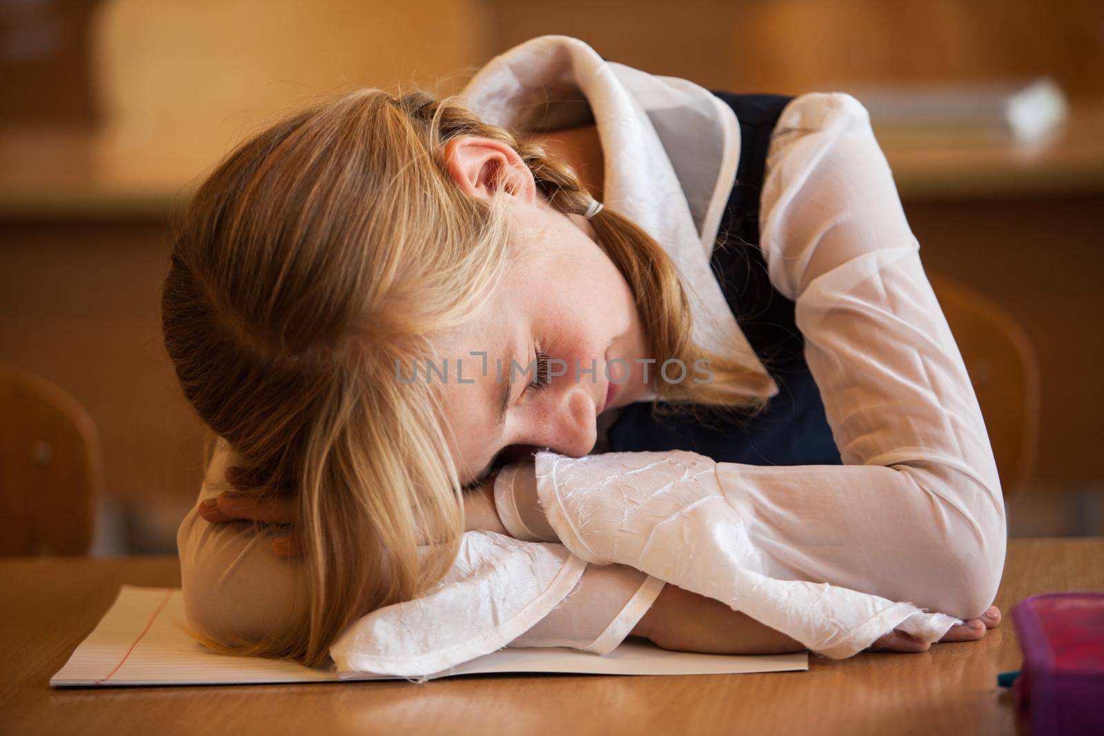 School Girl is sleeping on the desk at the boring lesson
