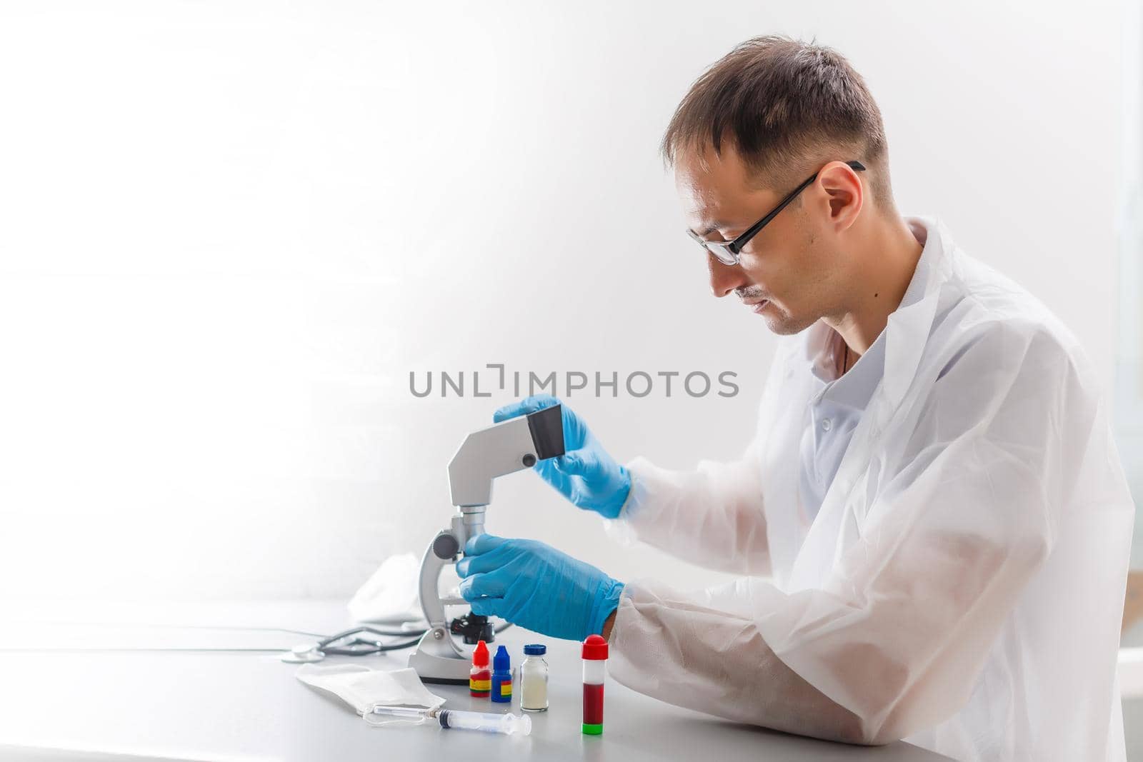 young male researcher carrying out scientific research in a lab by Andelov13