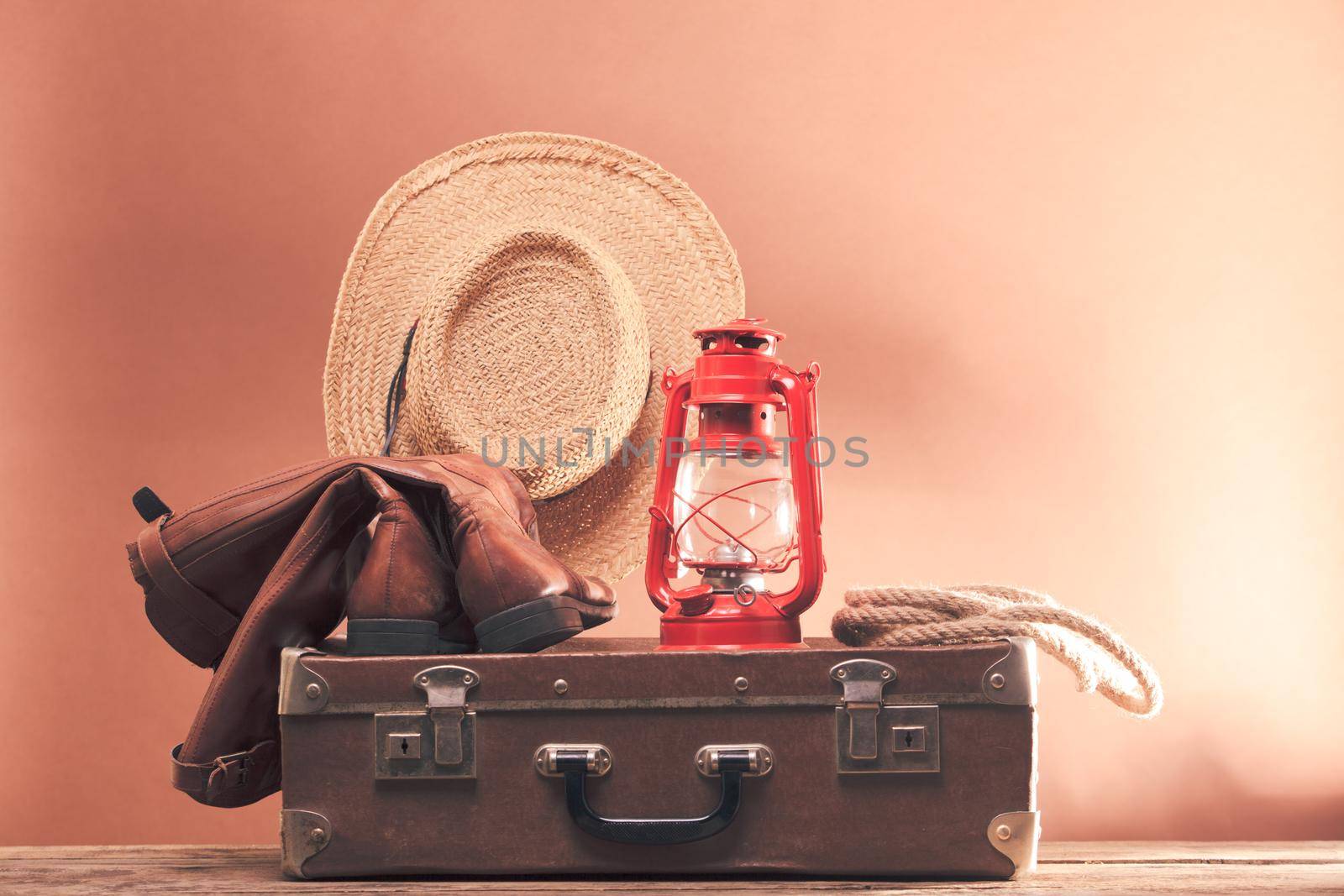 Old vintage suitcase and leather footwear with stetson and kerosene lamp
