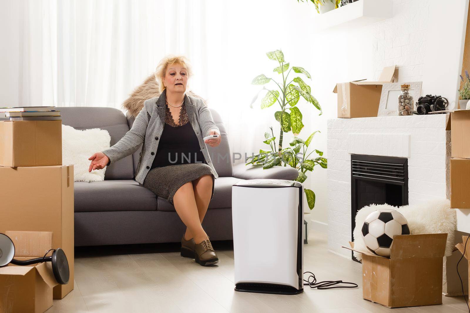 elderly woman next to an air purifier moving to a new apartment