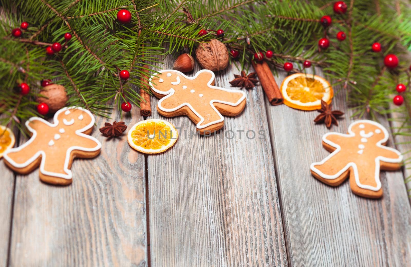 Gingerbreads and fir tree branches on the wooden table. Christmas decor