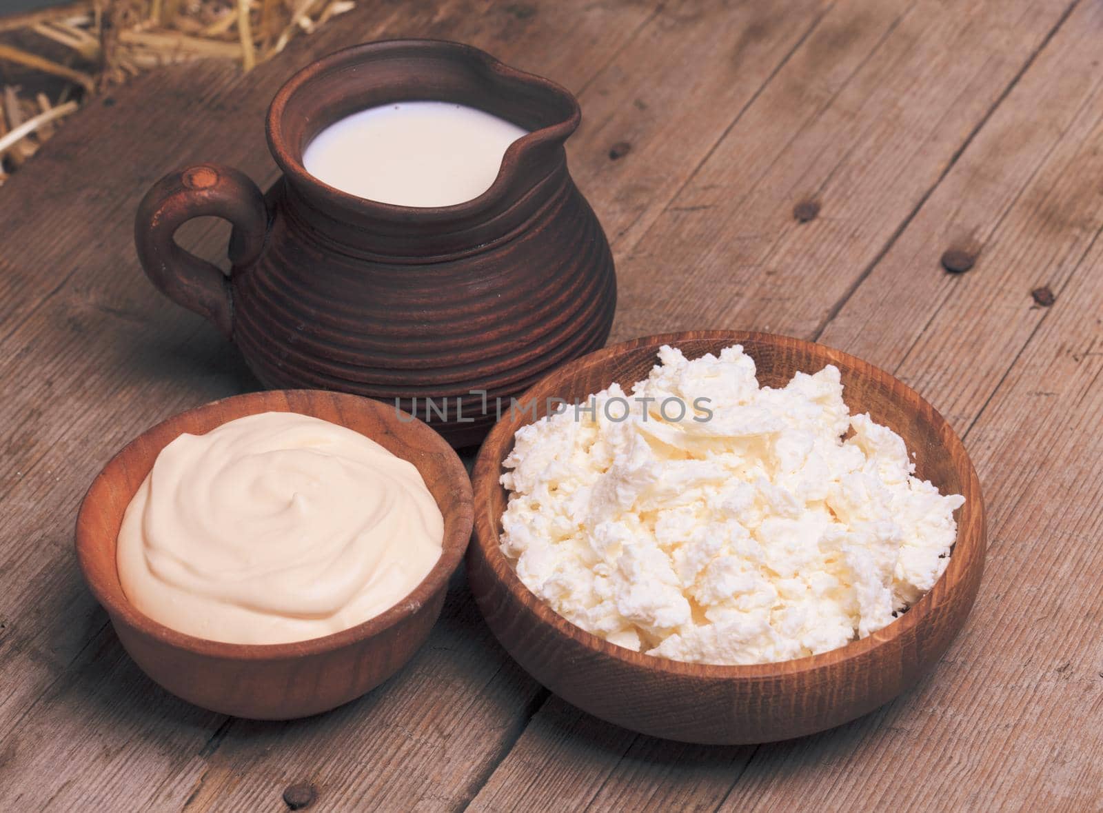 Milk, sour cream and curd on a wooden rustic board