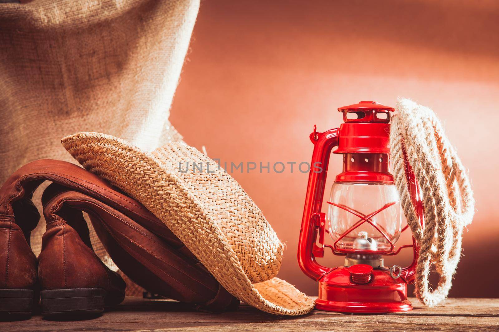 Old vintage cowboy tools - leather footwear, stetson, rope and kerosene lamp