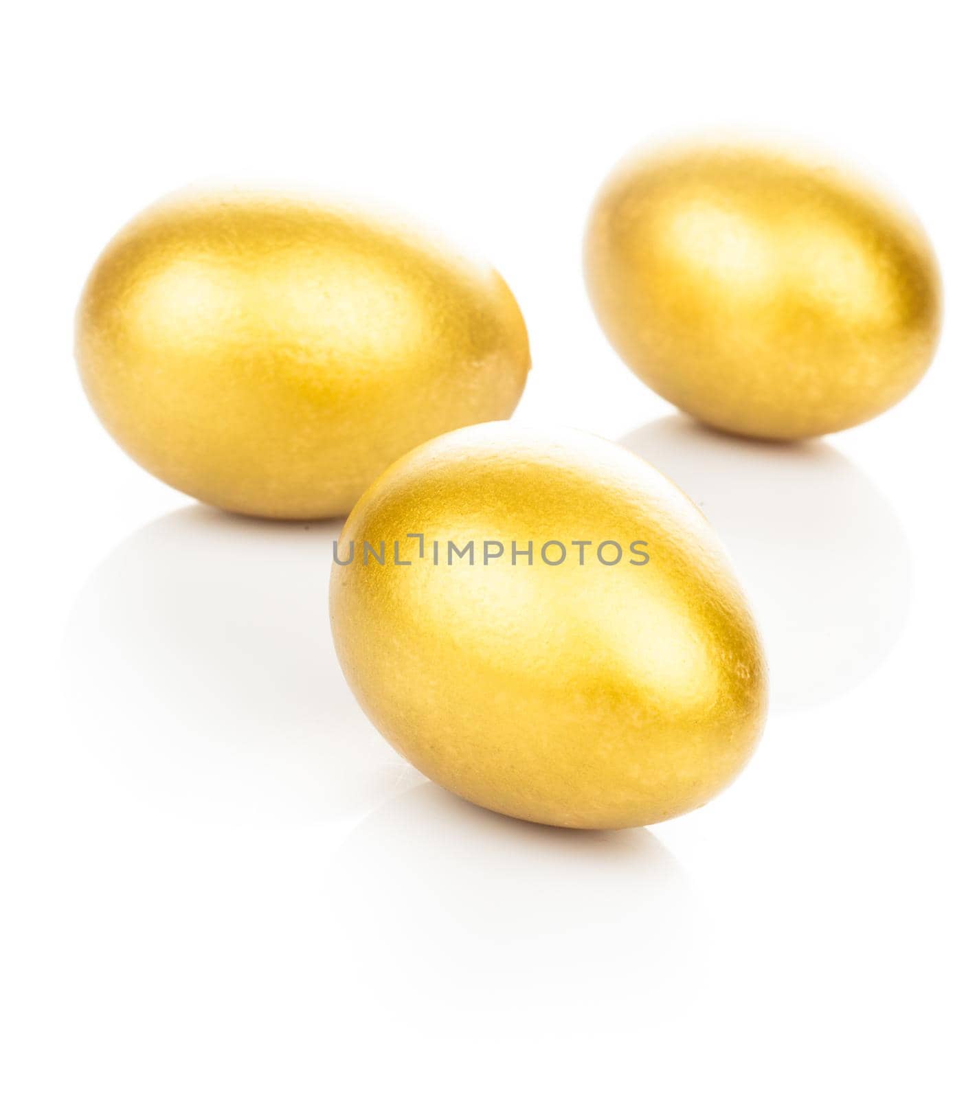 Three golden eggs isolated on white background