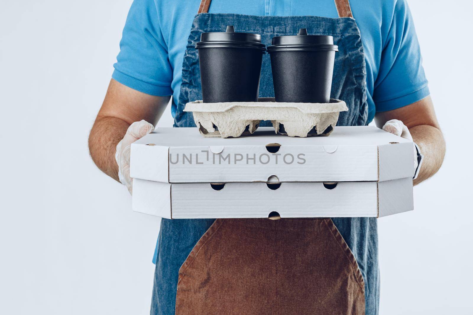 Unrecognizable man in blue polo shirt with food delivery orders against light grey background