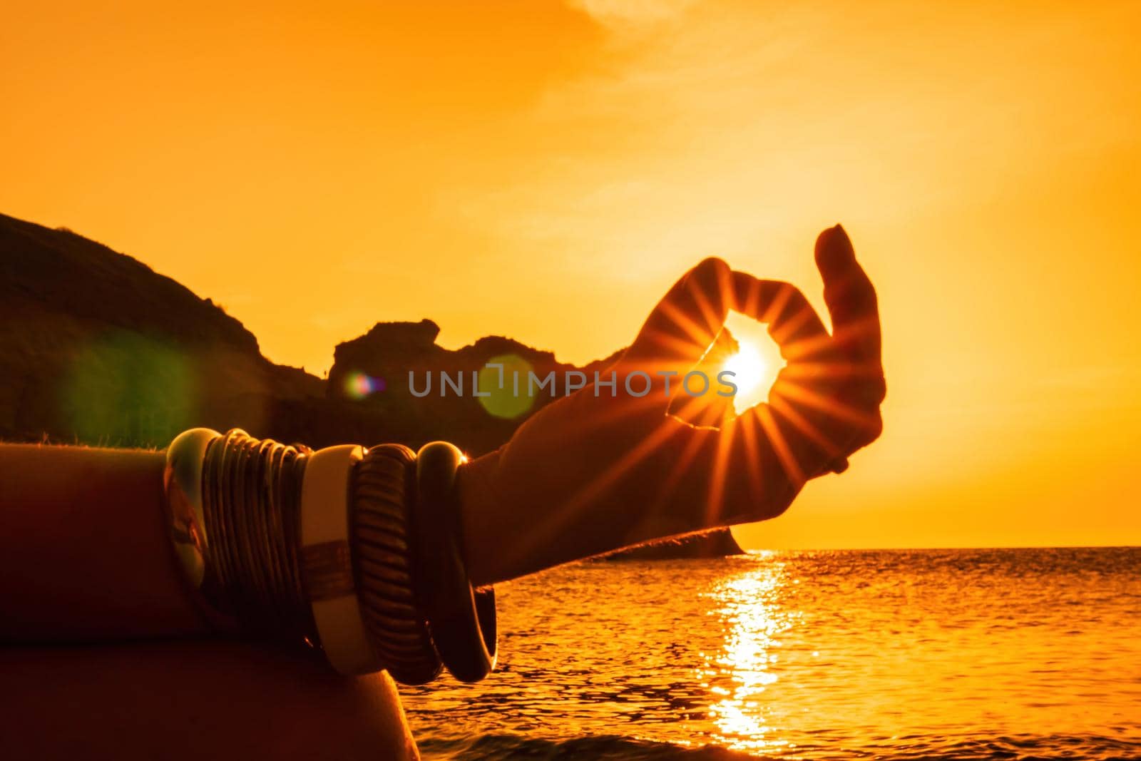 Young woman in swimsuit with long hair practicing stretching outdoors on yoga mat by the sea on a sunny day. Women's yoga fitness pilates routine. Healthy lifestyle, harmony and meditation concept.