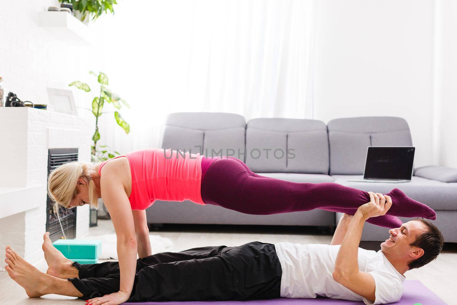 Young man and woman woman doing exercise in the sunny room