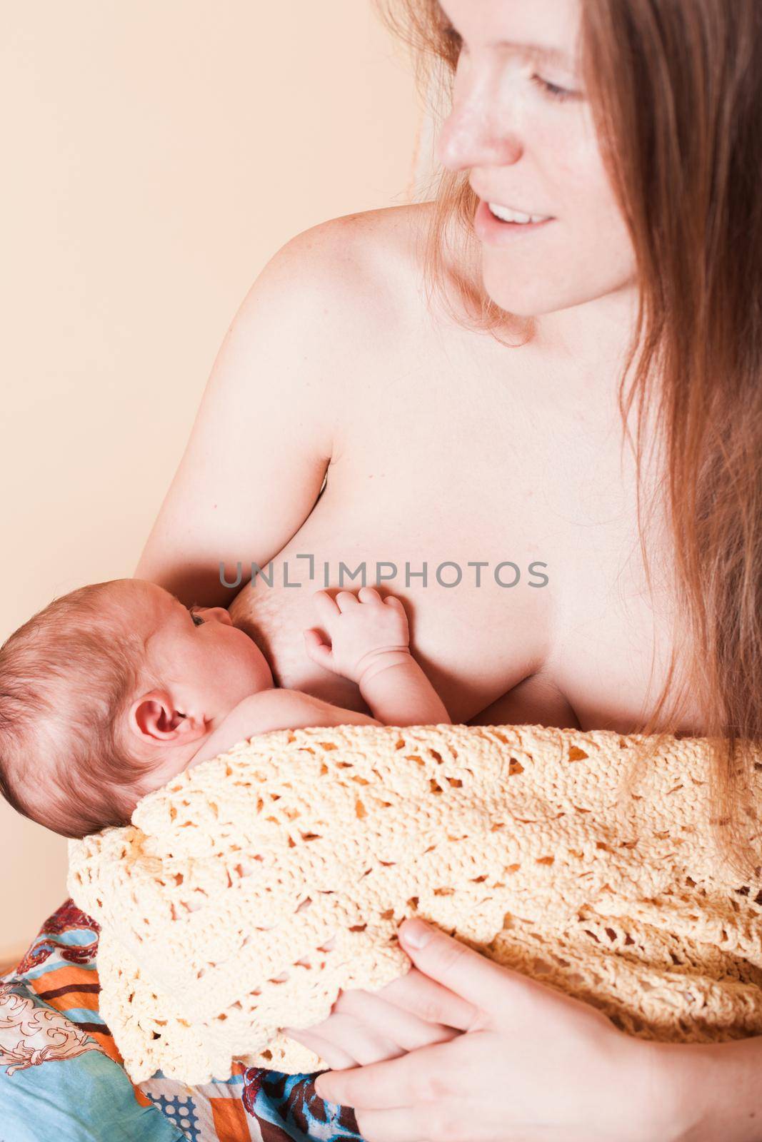 Mother with her newborn nursing baby, sitting on a draws rocking