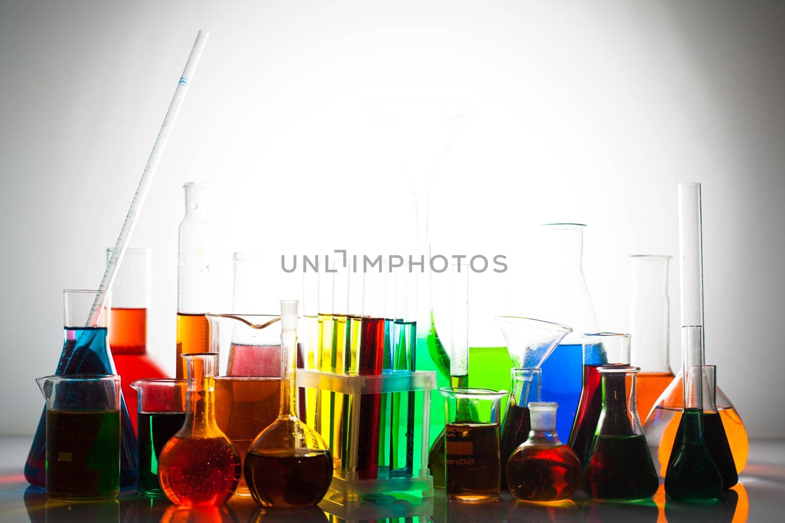 Laboratory glass with rainbow color liquids, chemistry still life