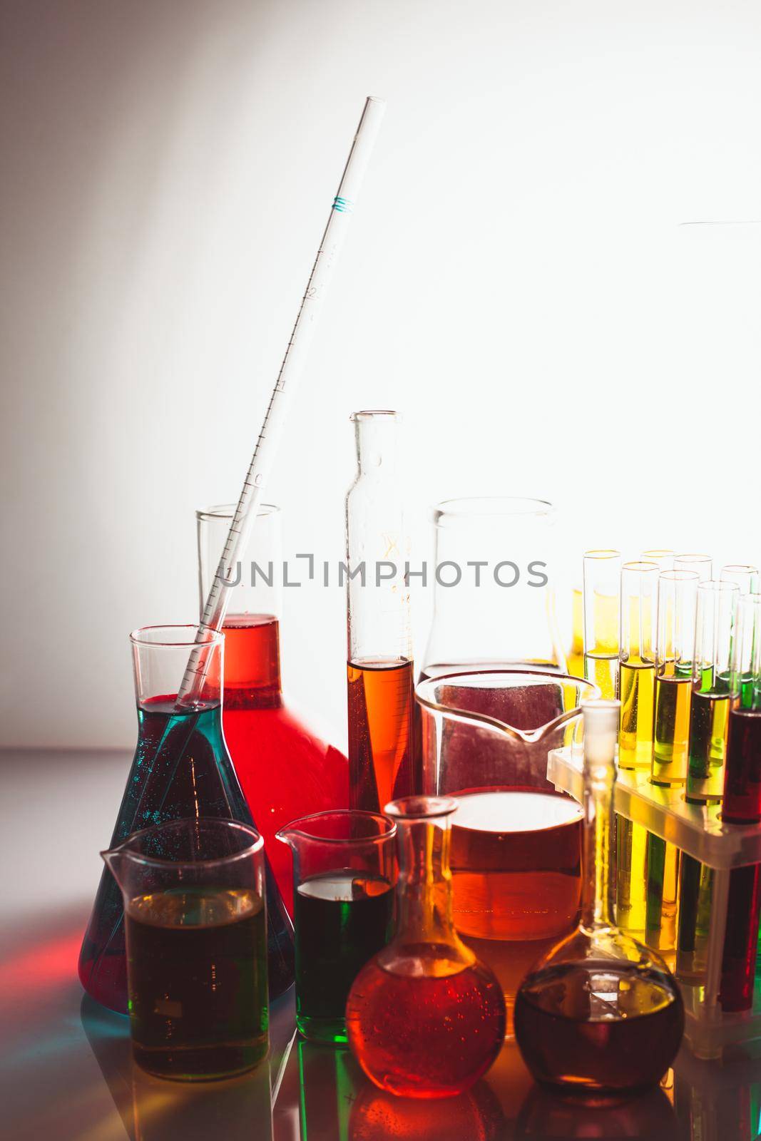 Laboratory glass with rainbow color liquids, chemistry still life