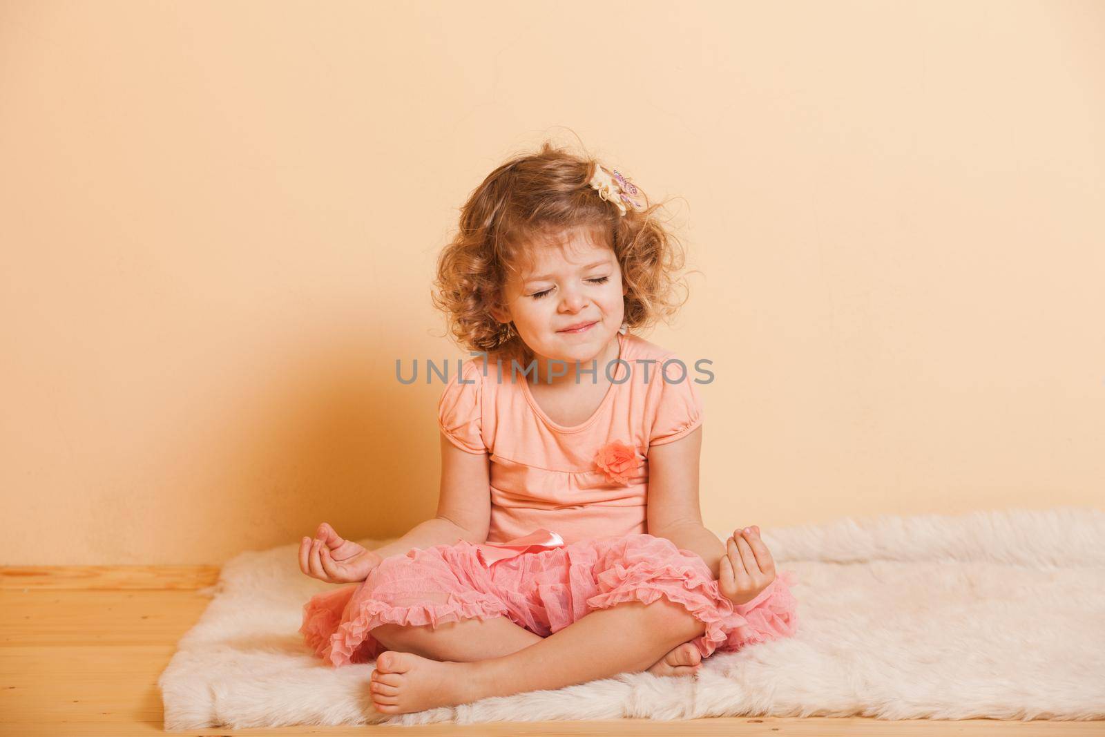 Little girl plays yoga in the home