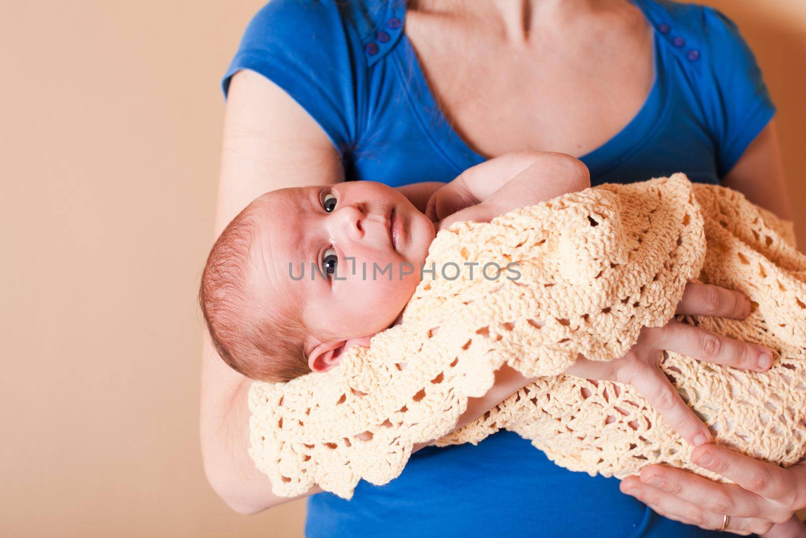 Mother with her newborn baby, standing near wall