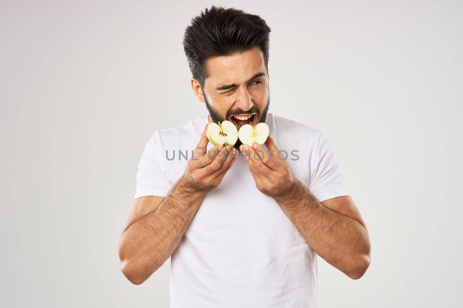 emotional bearded man with apple in his hands fruit snack. High quality photo