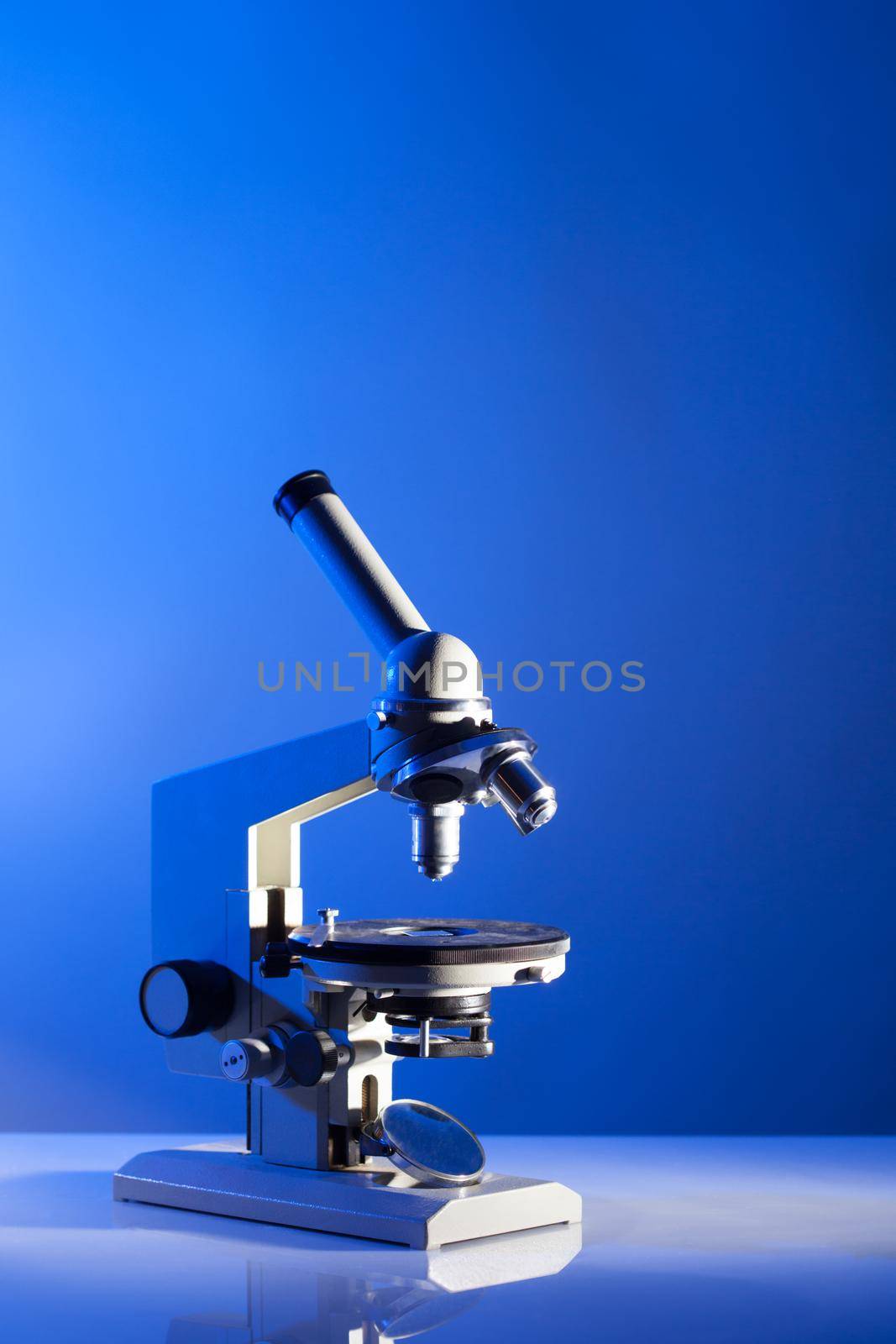 Microscope on the table in laboratory with blue light