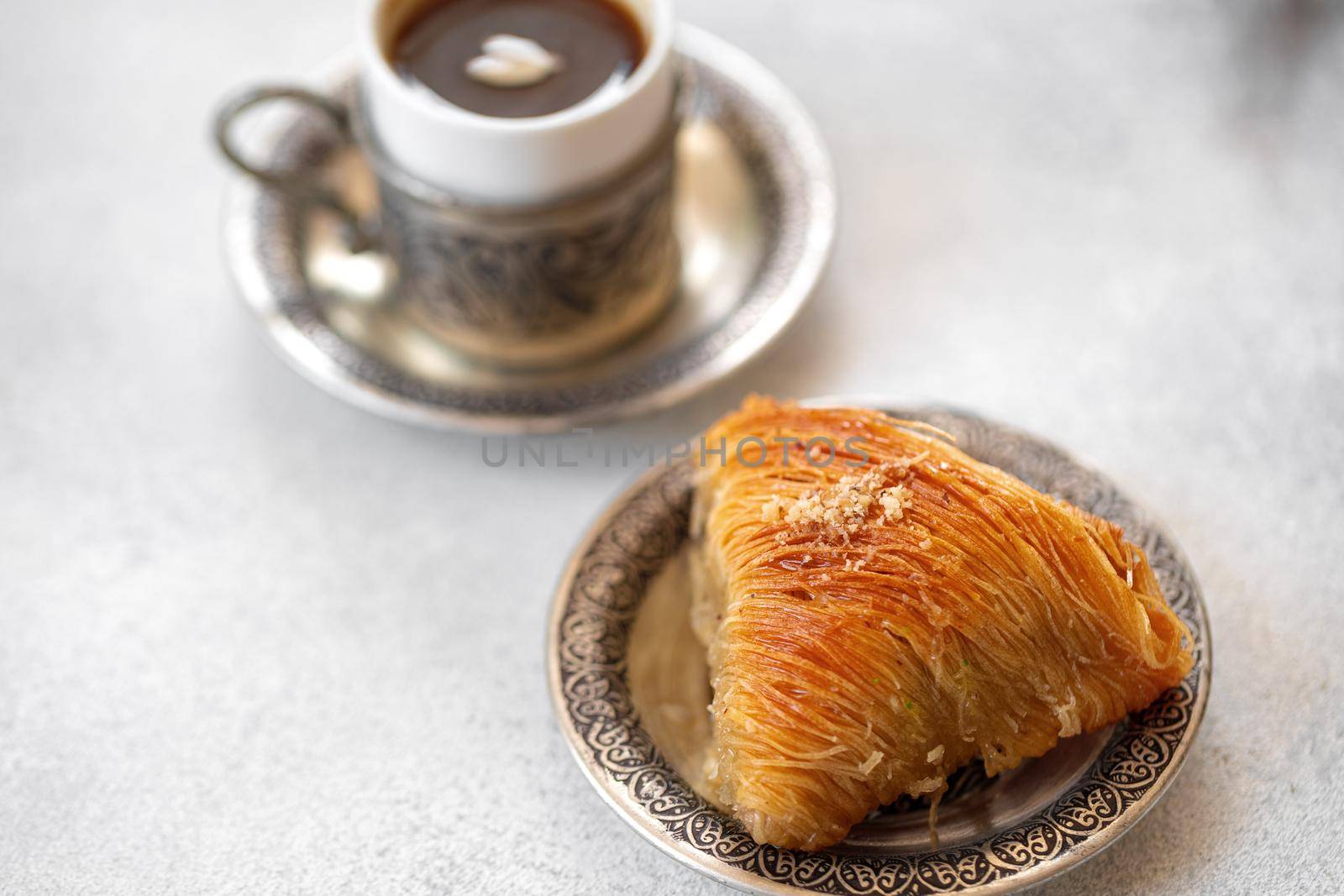 Small cup of Turkish coffee and Turkish baklava on table