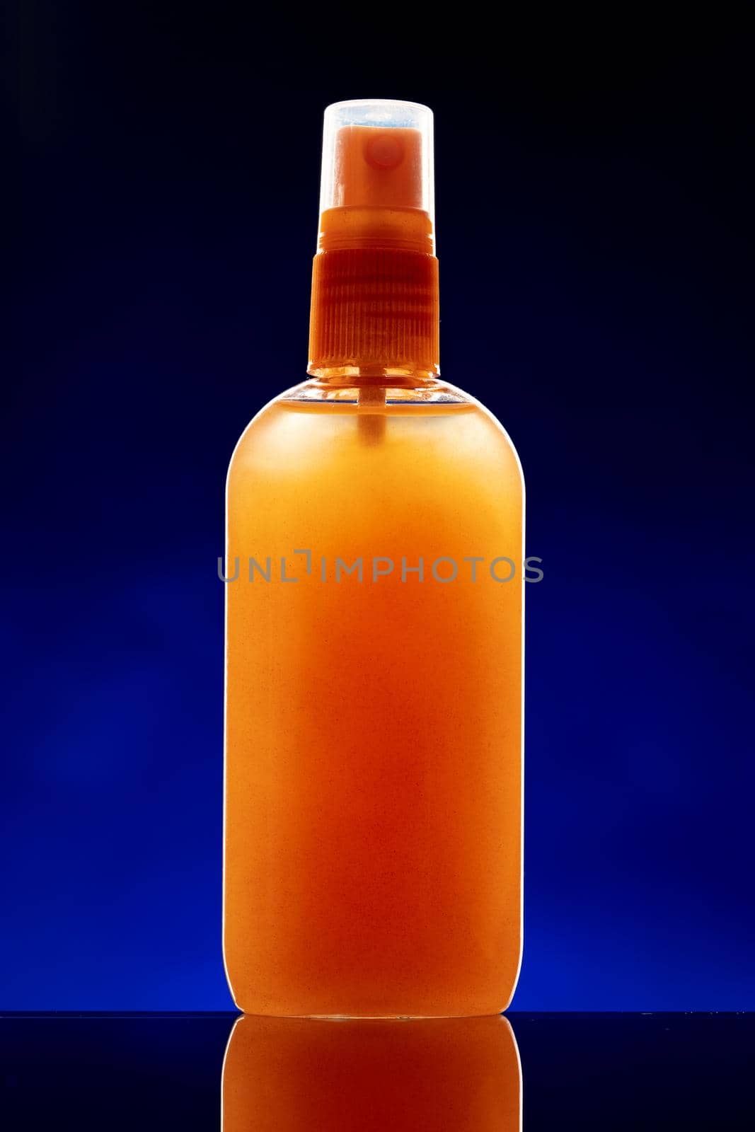 Glass bottle with cosmetic oil on dark background close up