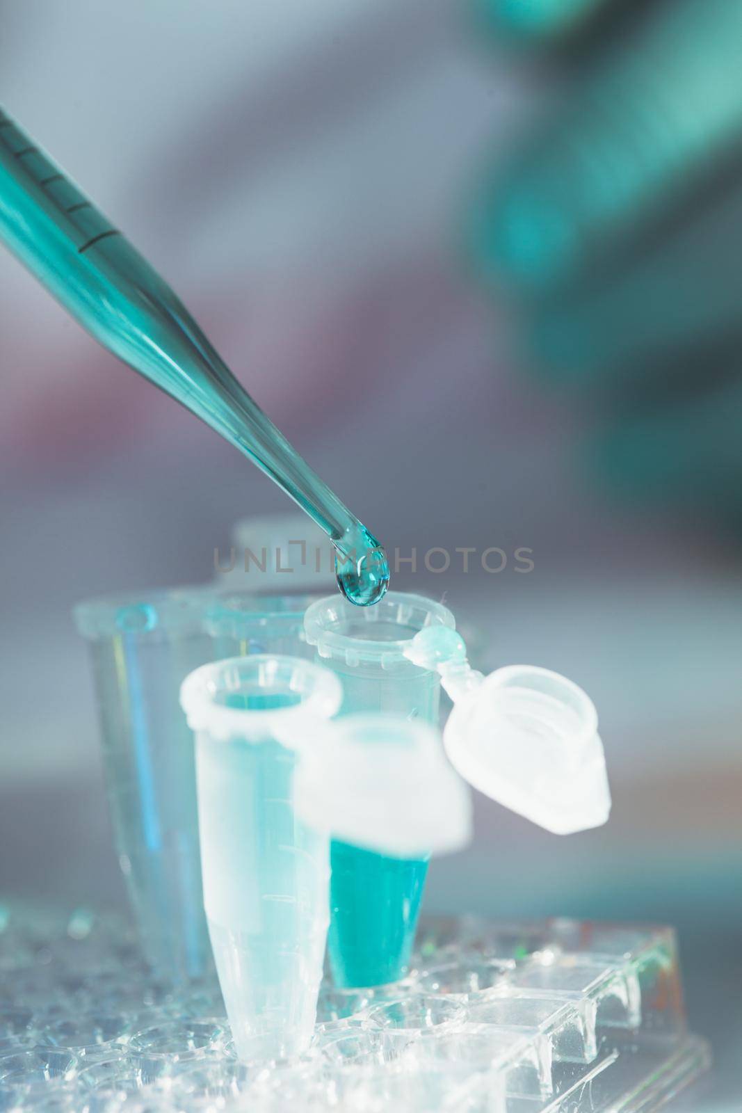 Scientist holds pipette and drops into eppendorf tube