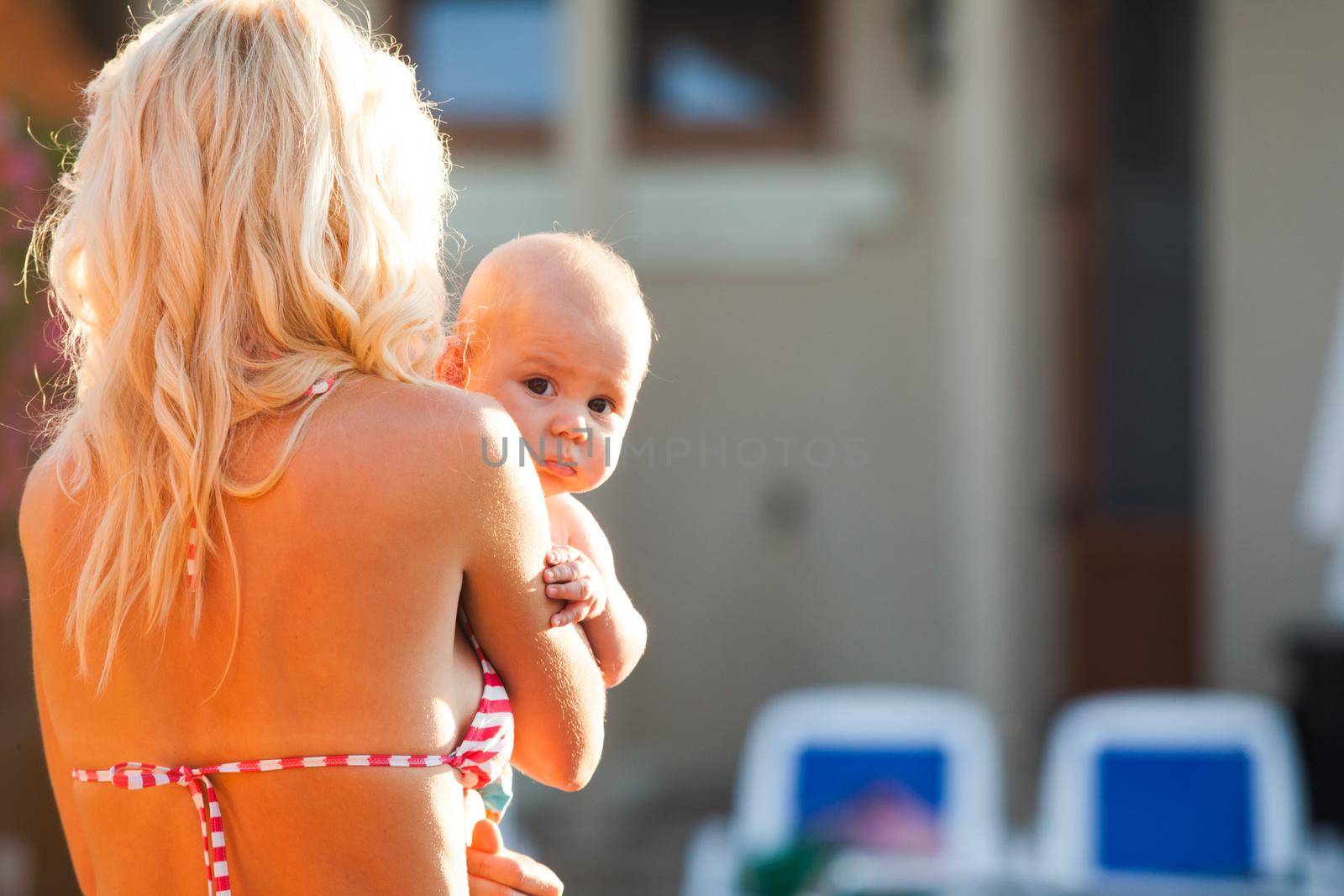 Pretty young mom with baby at the swimming pool