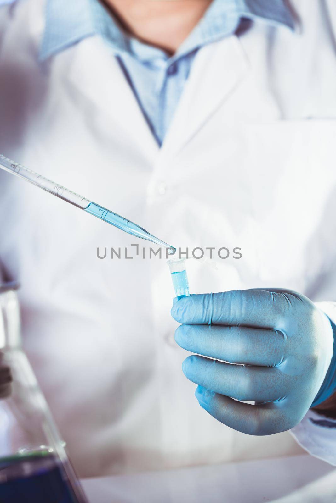 Scientist holds eppendorf tube and pipette. Focus on test tube