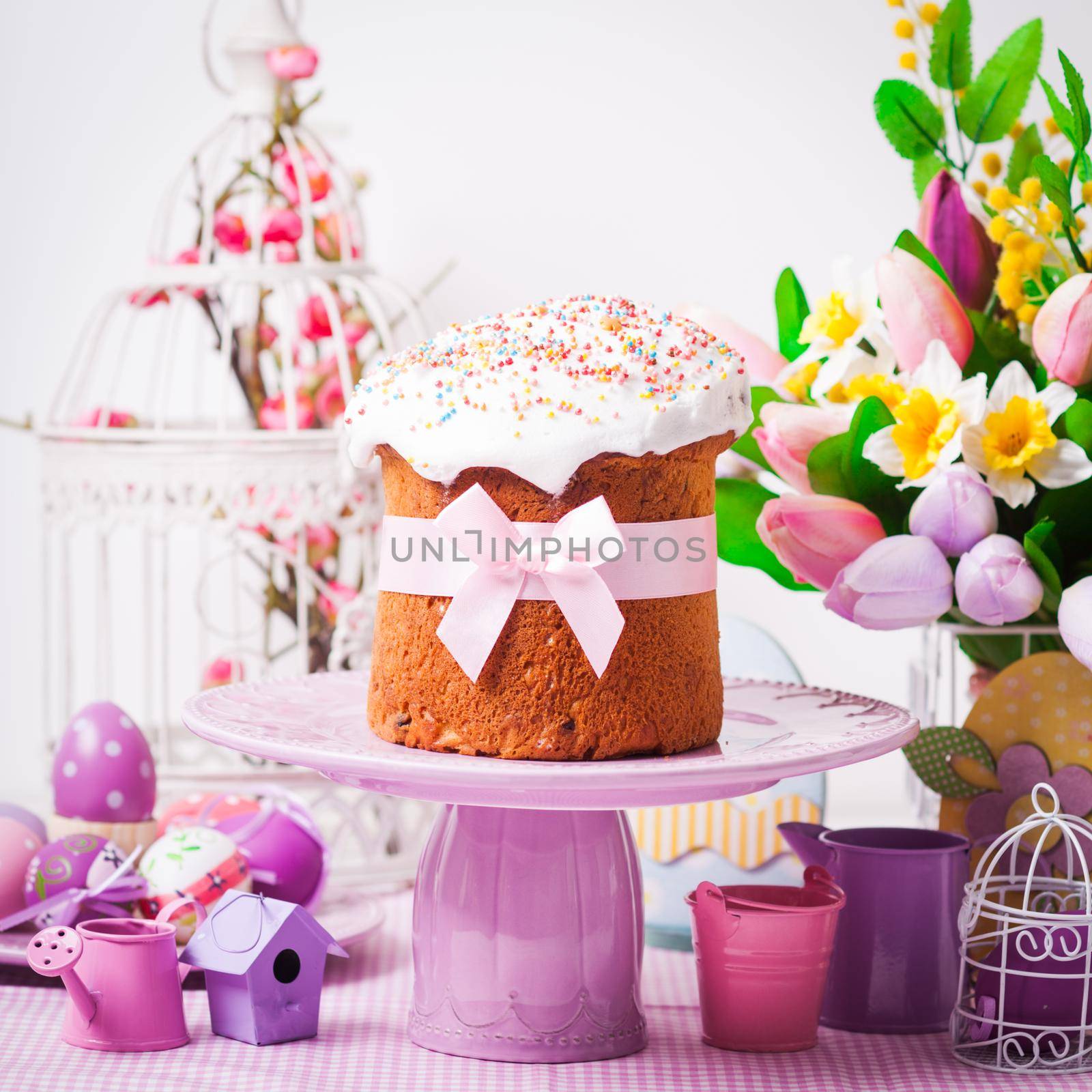 Easter cake on the cake stand and flowers, lilac desorations on the foreground