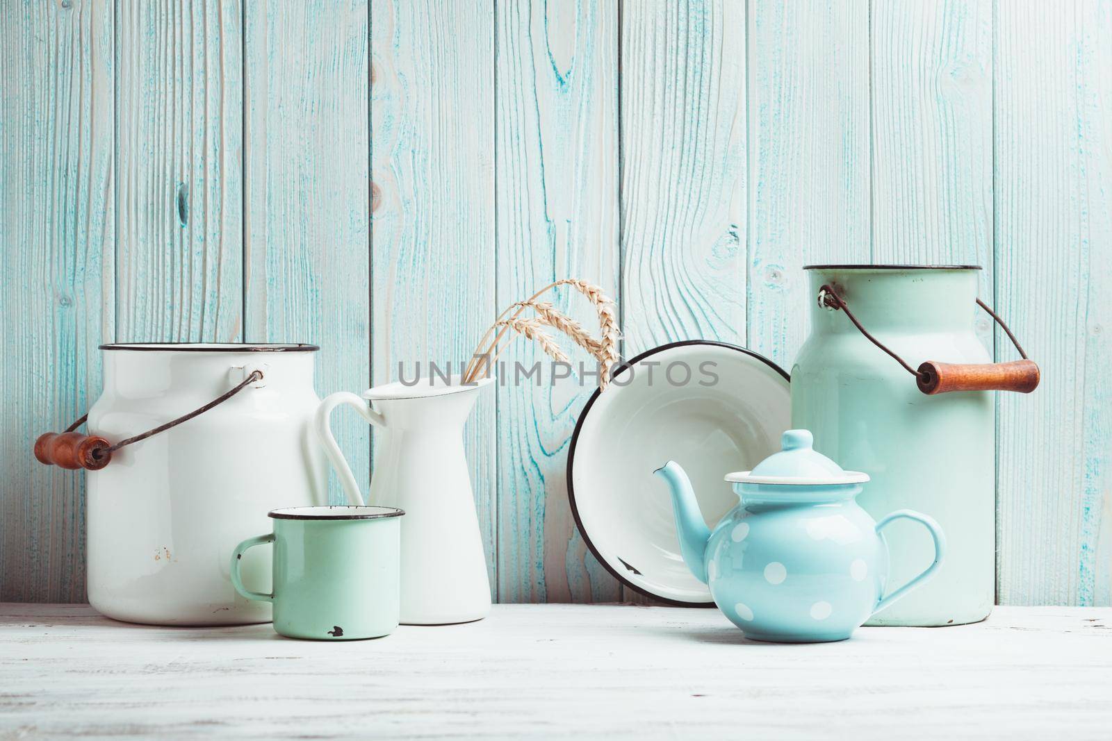 Enamelware on the kitchen table over blue wooden wall