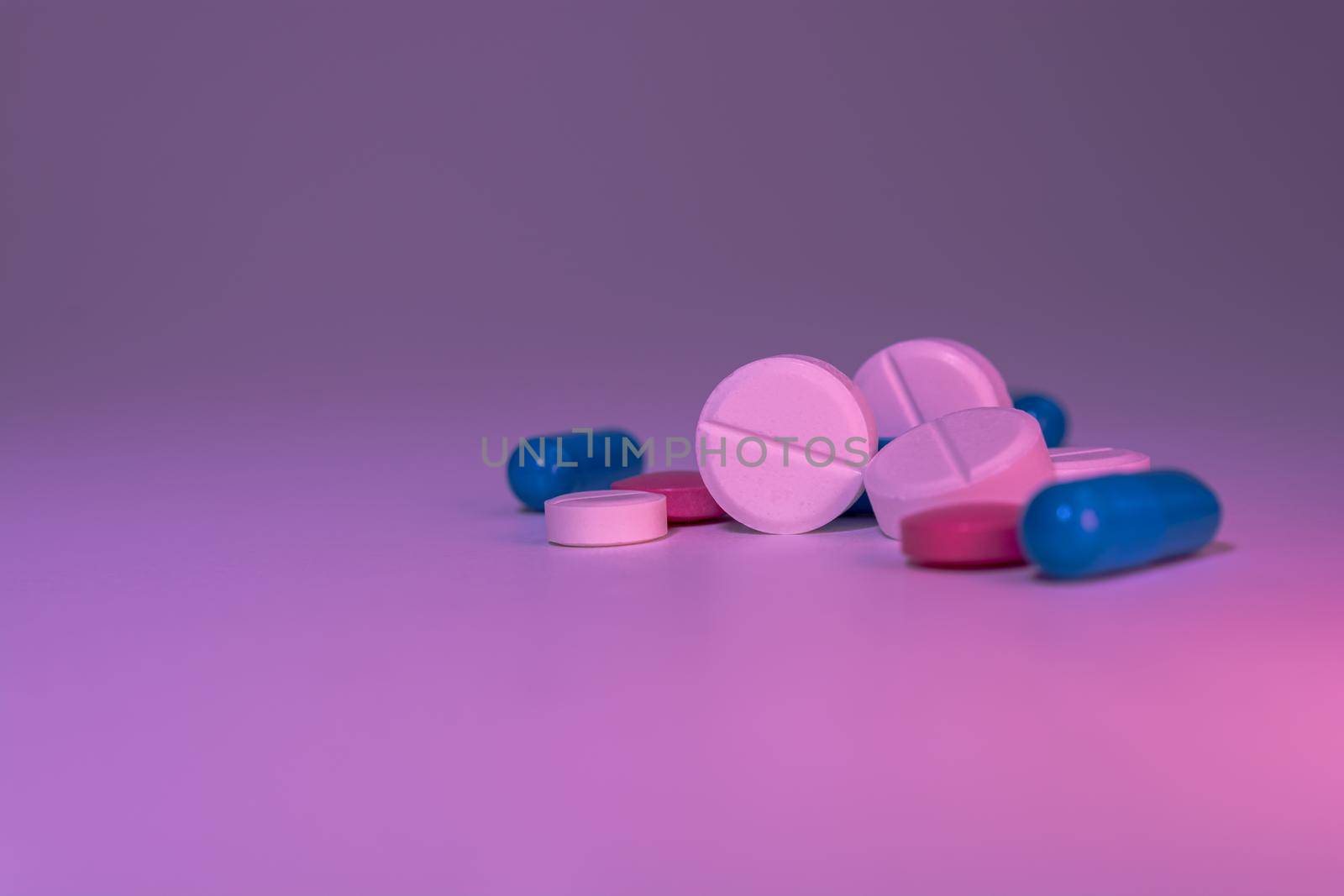 A pile of medical pills on a gray-pink background. Medications. Selective focus.