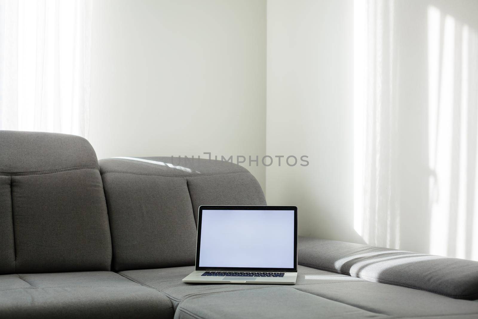 Modern interior. Comfortable workplace. The laptop is on the couch