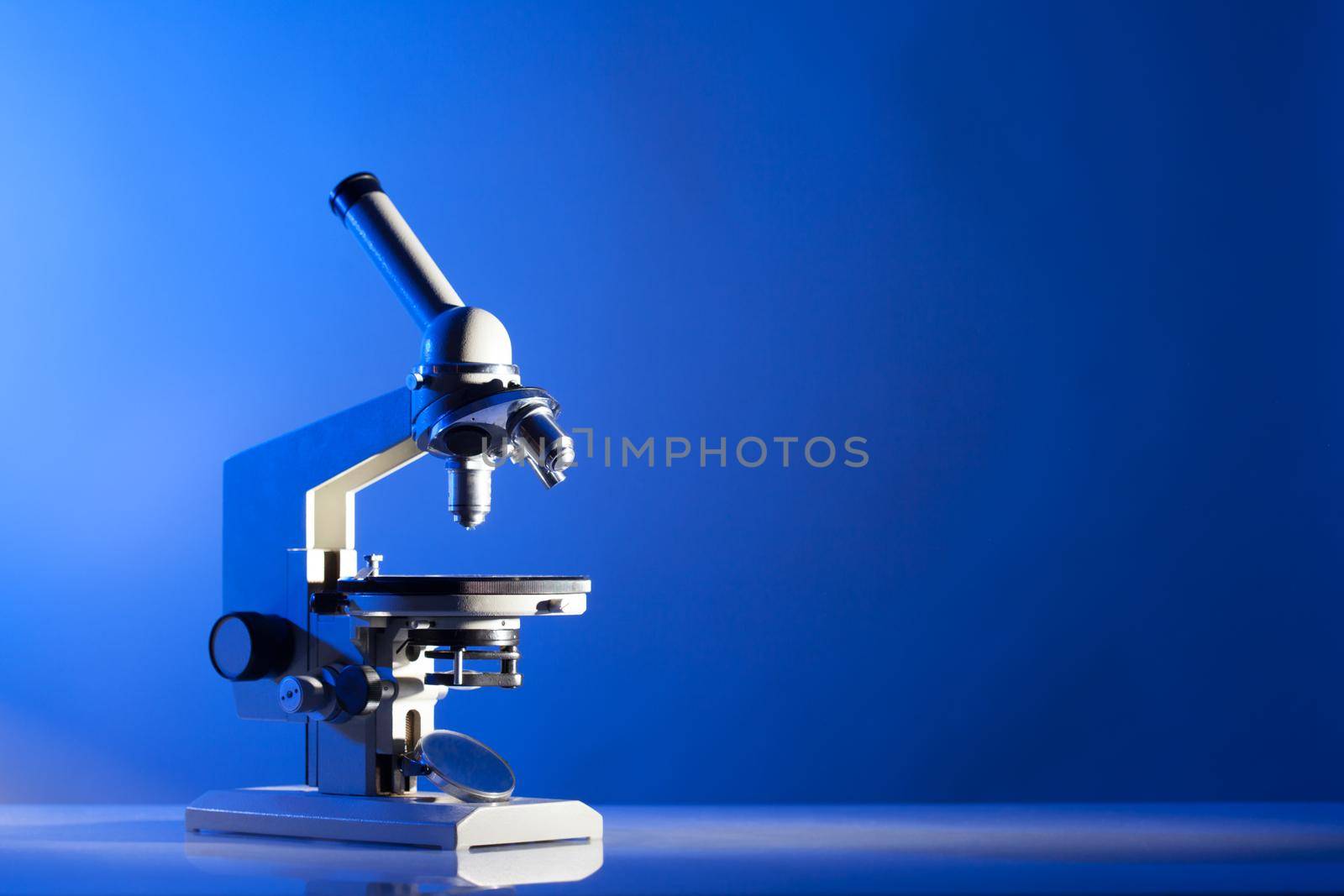 Microscope on the table in laboratory with blue light