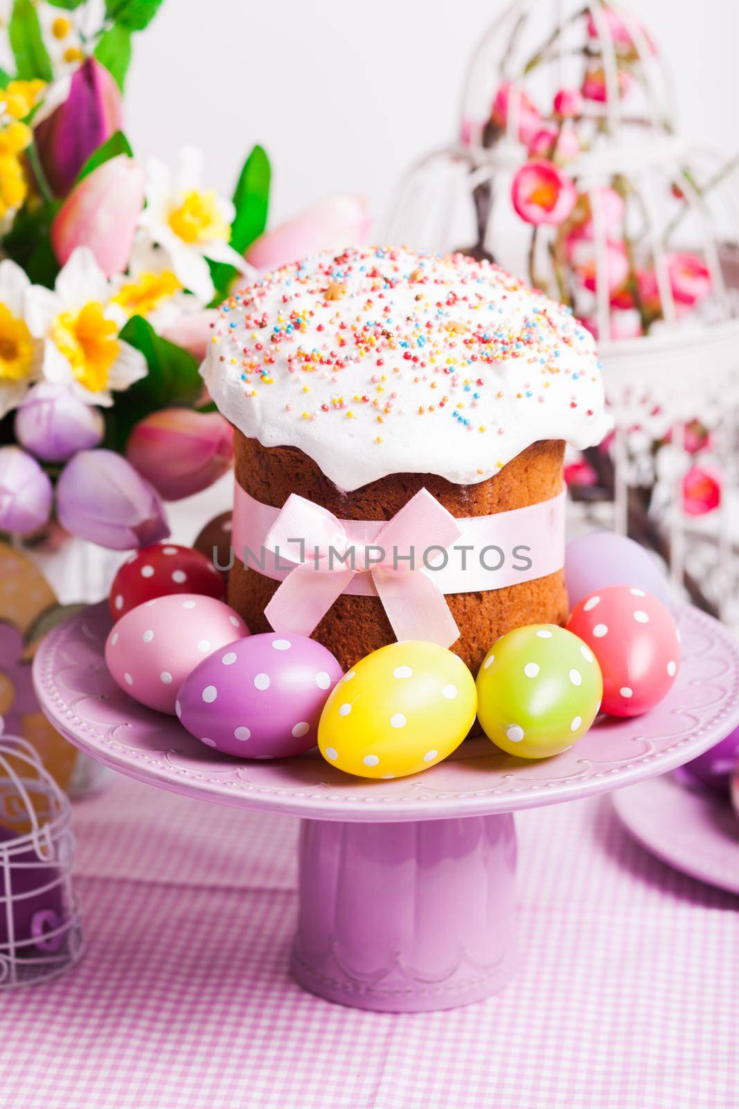 Easter cake and colorful polka dot eggs on the plate and flowers on the foreground