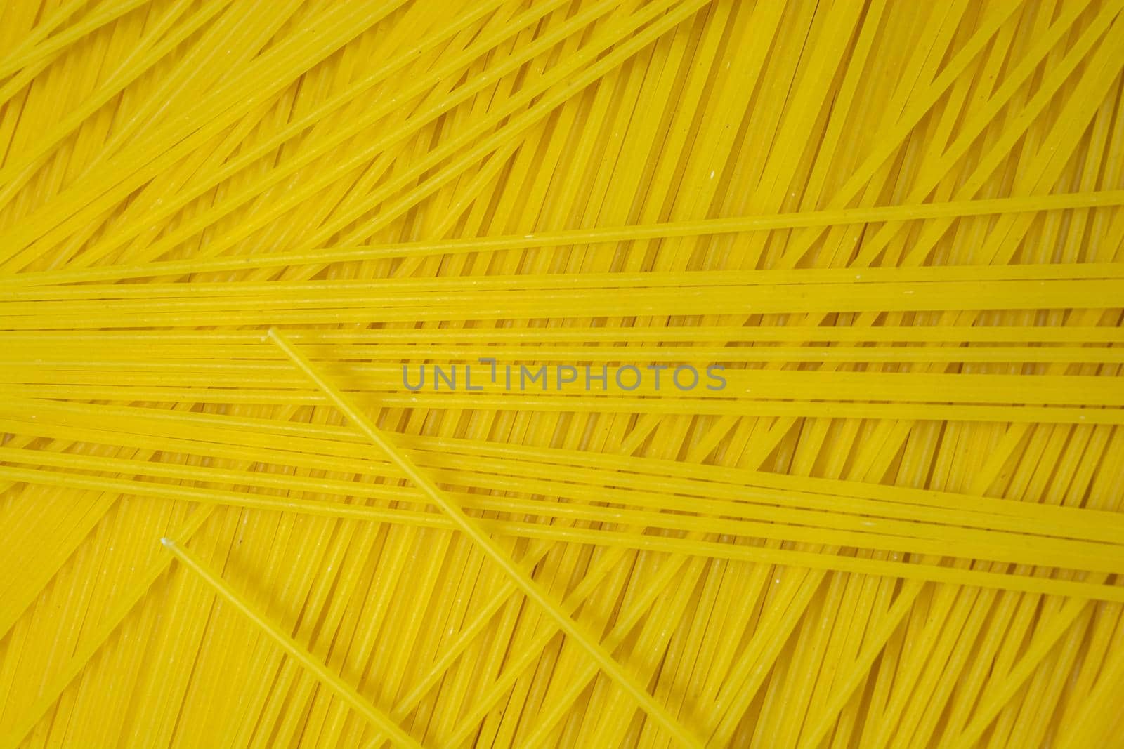 Abstract background of long and thin spaghetti. Raw pasta. Culinary theme.