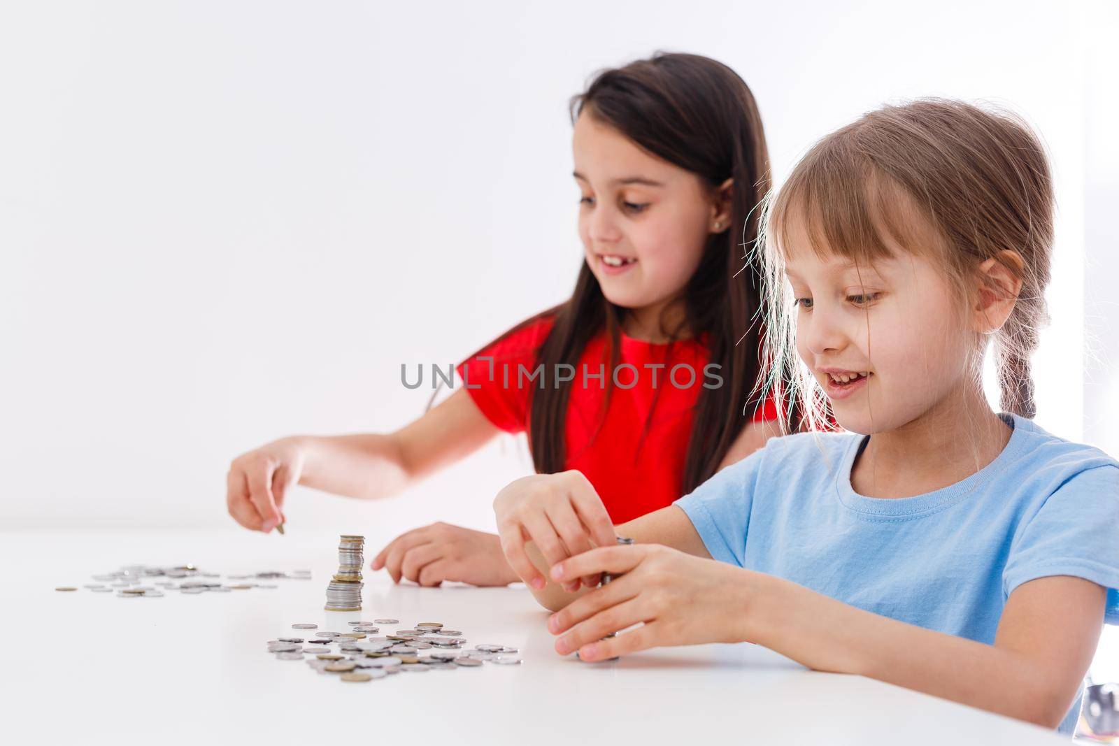 portrait of little girls sitting at table and calculating money