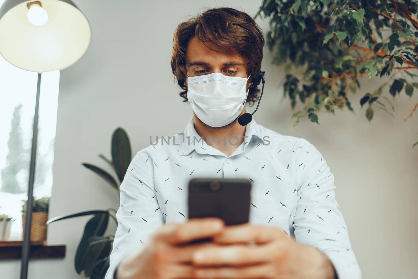 Man in medical mask working from home while coronavirus quarantine by Fabrikasimf